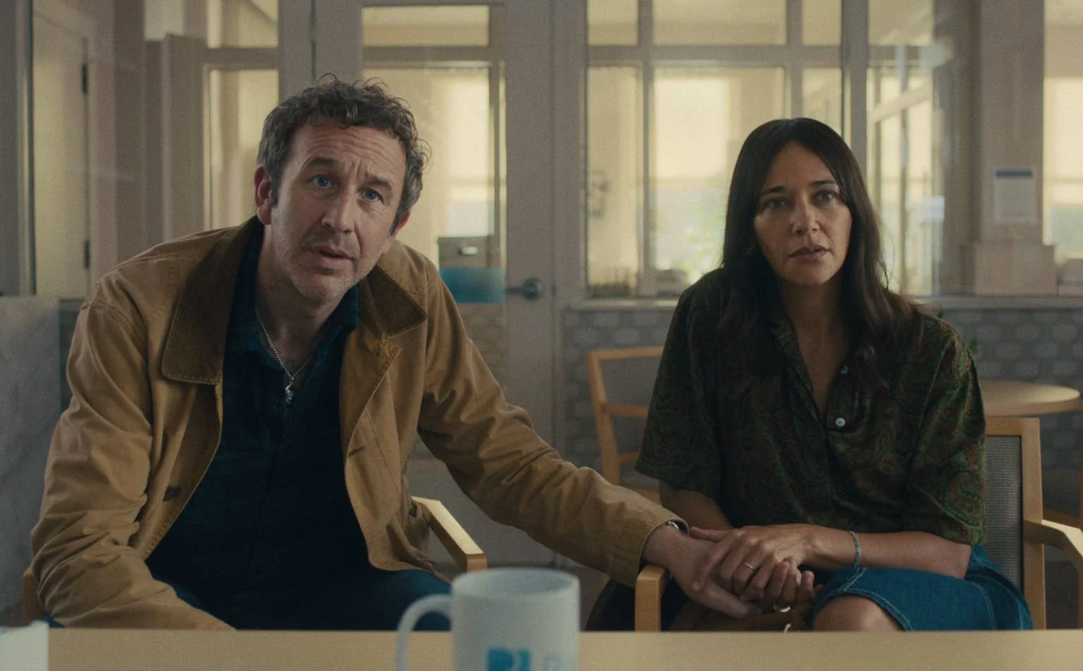 Chris O'Dowd and Rashida Jones sit together in a tense Black Mirror Season 7 scene.