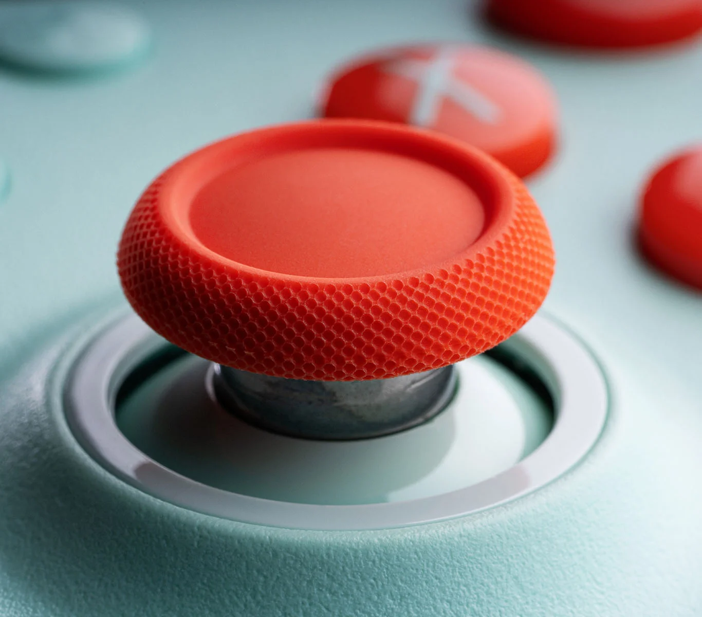 Close-up of a coral Ultimate 2C Wireless thumbstick and the ring around it