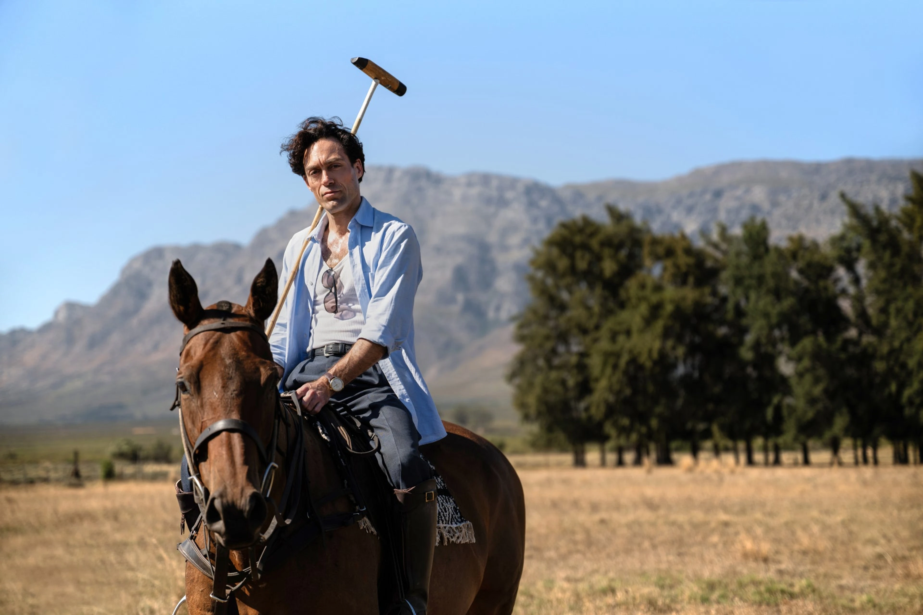 Alex Hassell as Rupert Campbell-Black sits on horseback in a Rivals Season 2 scene.