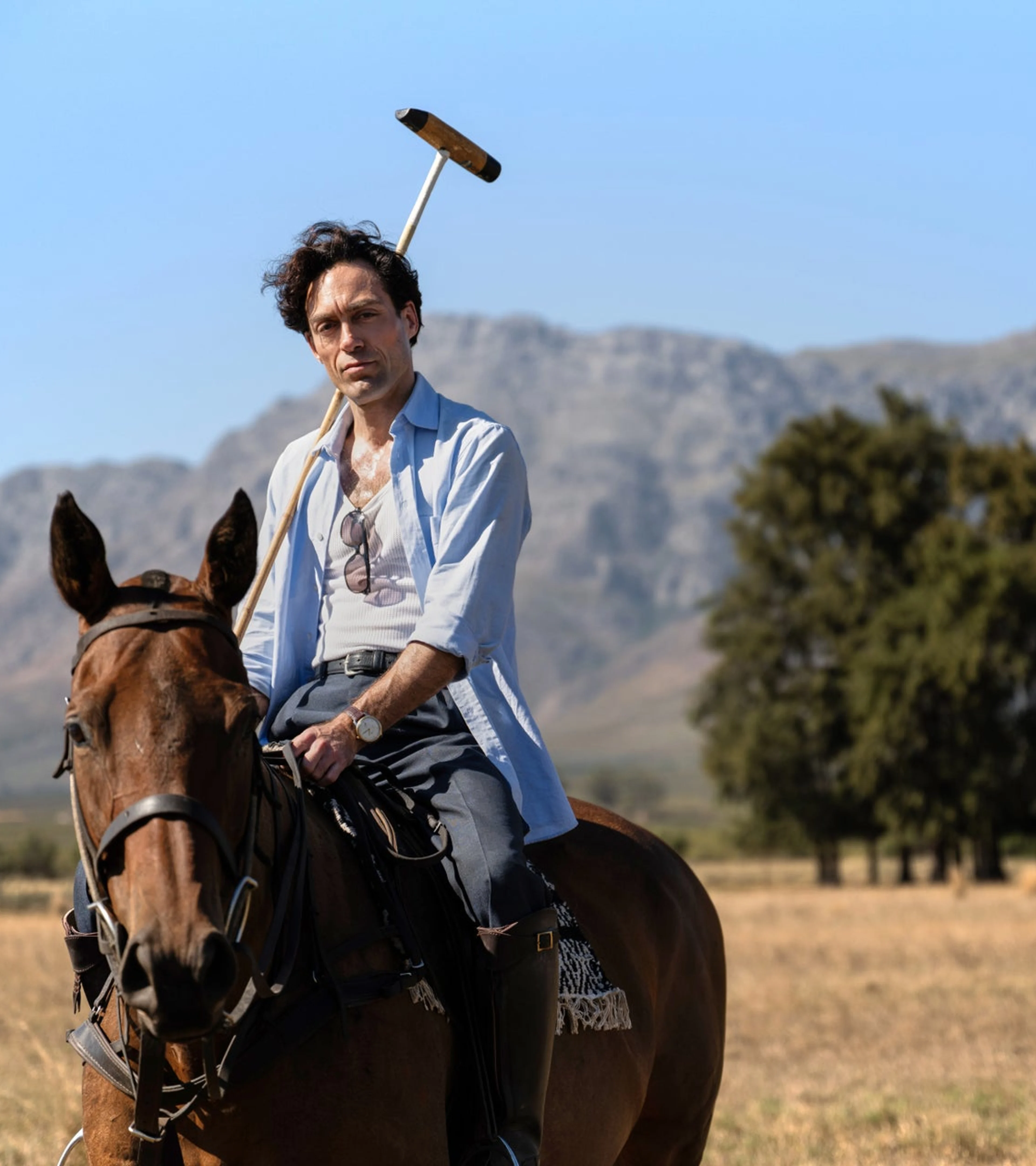 Alex Hassell as Rupert Campbell-Black sits on horseback in a Rivals Season 2 scene.