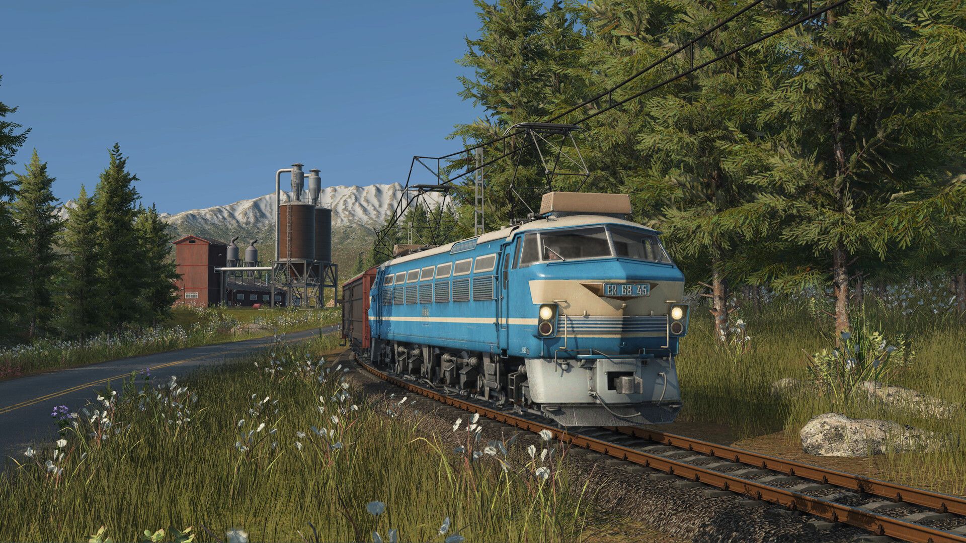 A blue train runs through forest in Transport Fever 3.