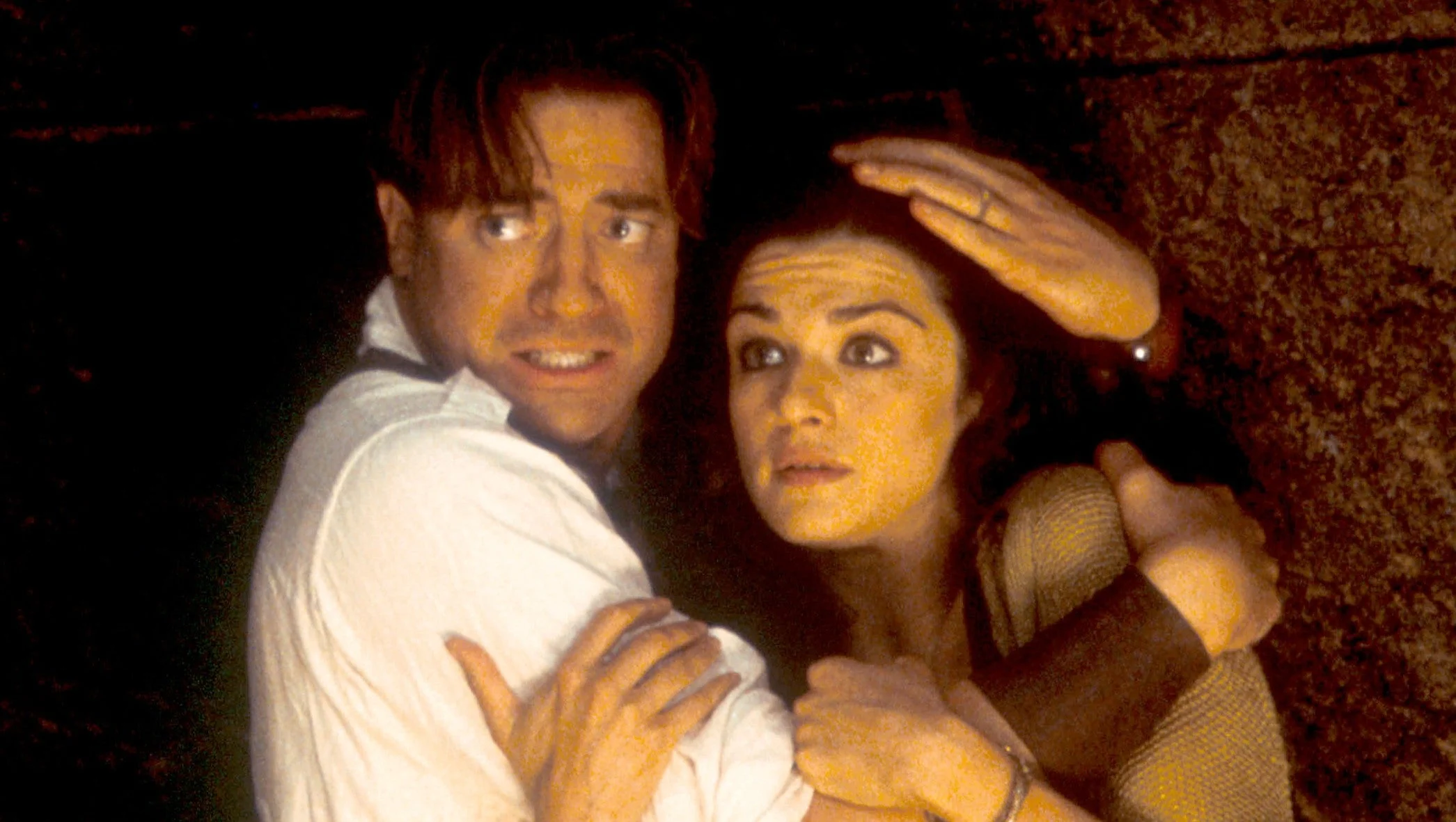 Rick O’Connell and Evelyn Carnahan shelter together inside an ancient chamber in The Mummy.