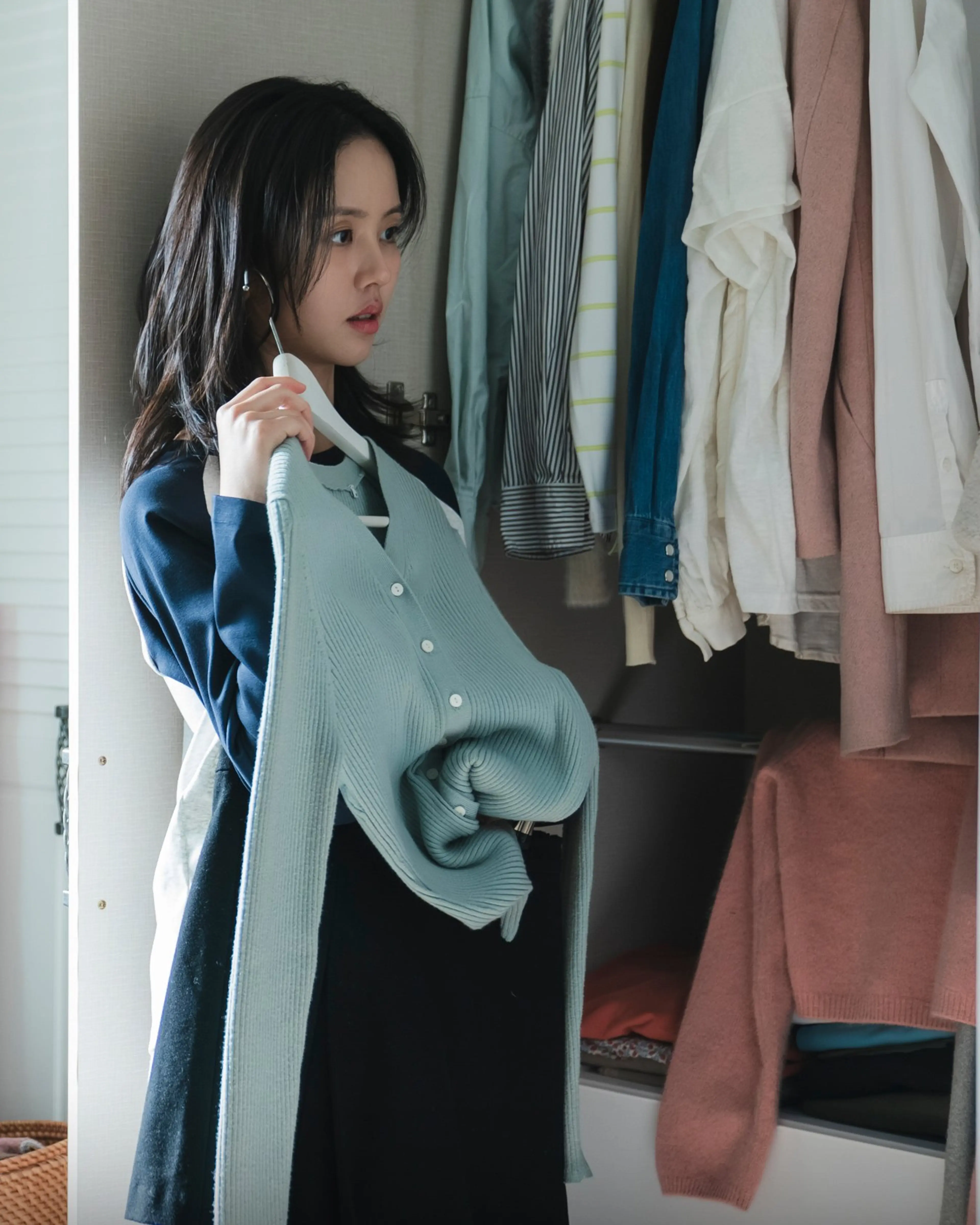 Kim So-hyun as Im Yu-jin choosing clothes in a room filled with fabric.