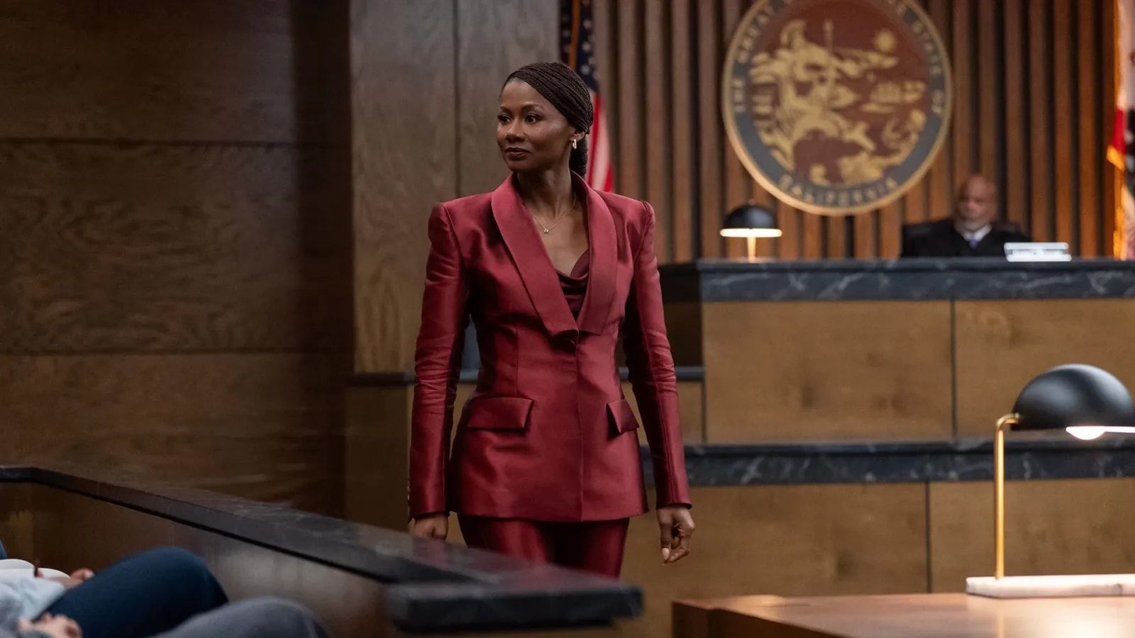 Jax Stewart in a burgundy suit stands in court.