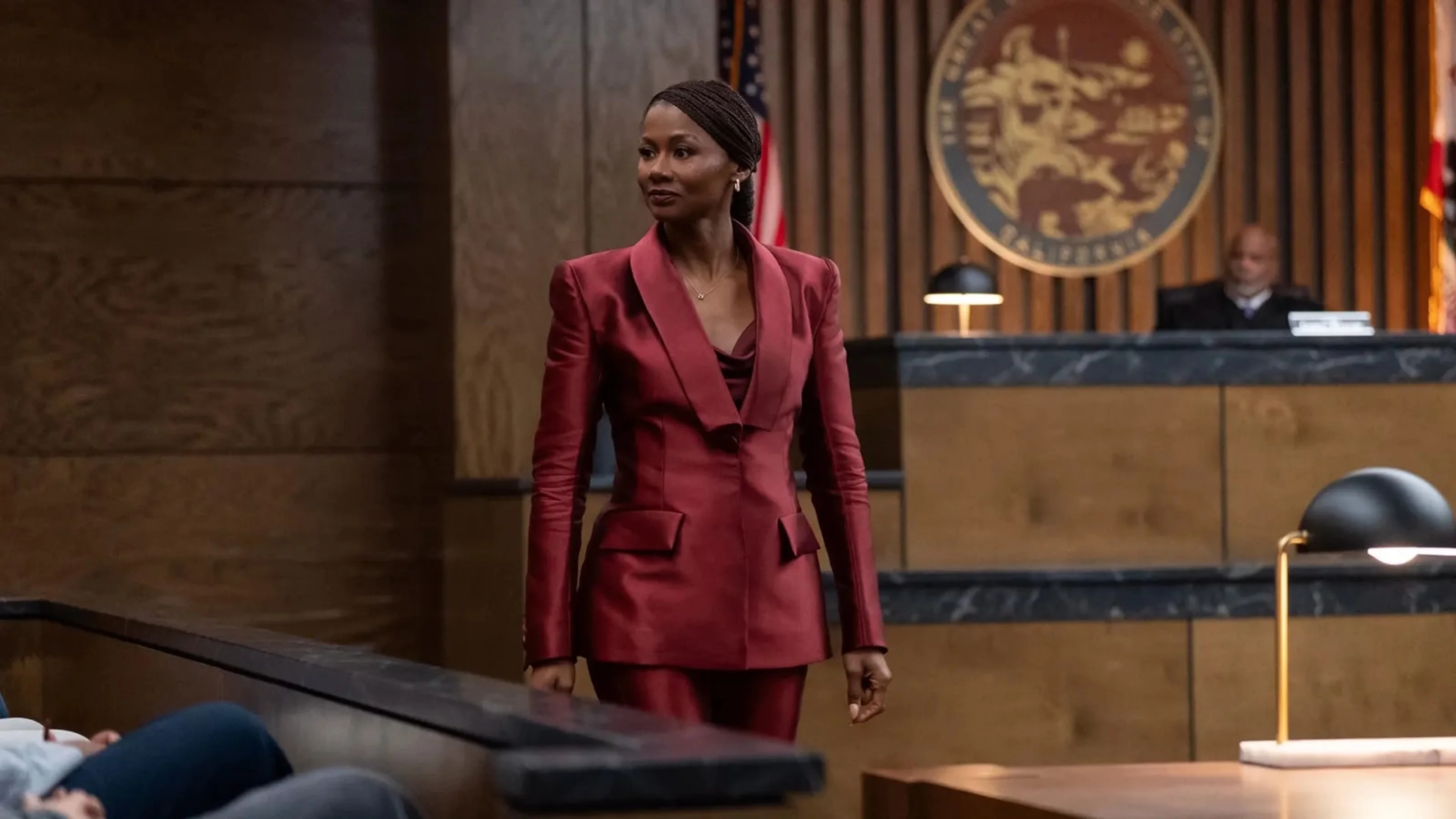 Jax Stewart in a burgundy suit stands in court.