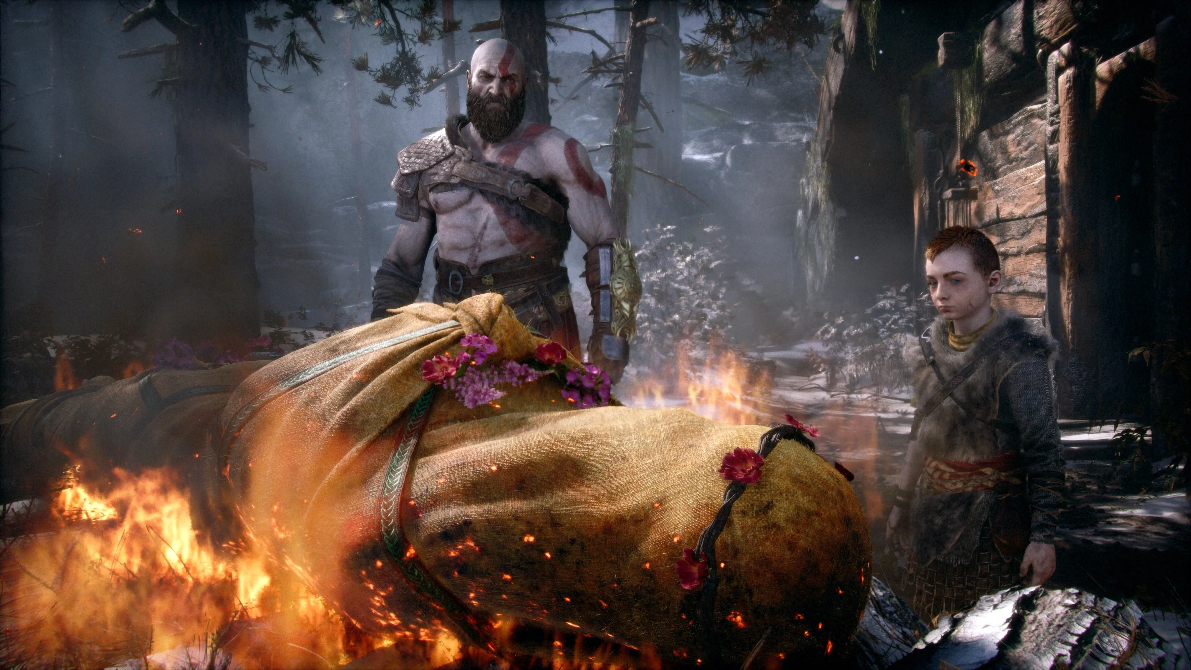 Kratos and Atreus stand beside Faye’s funeral pyre in God of War.