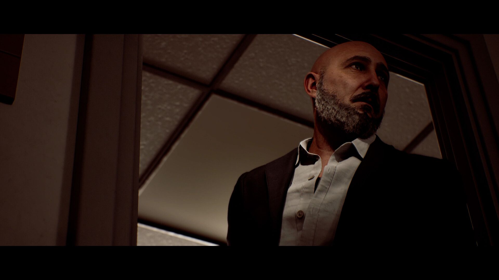 Richard has a grey beard and wears a waistcoat over a white shirt.