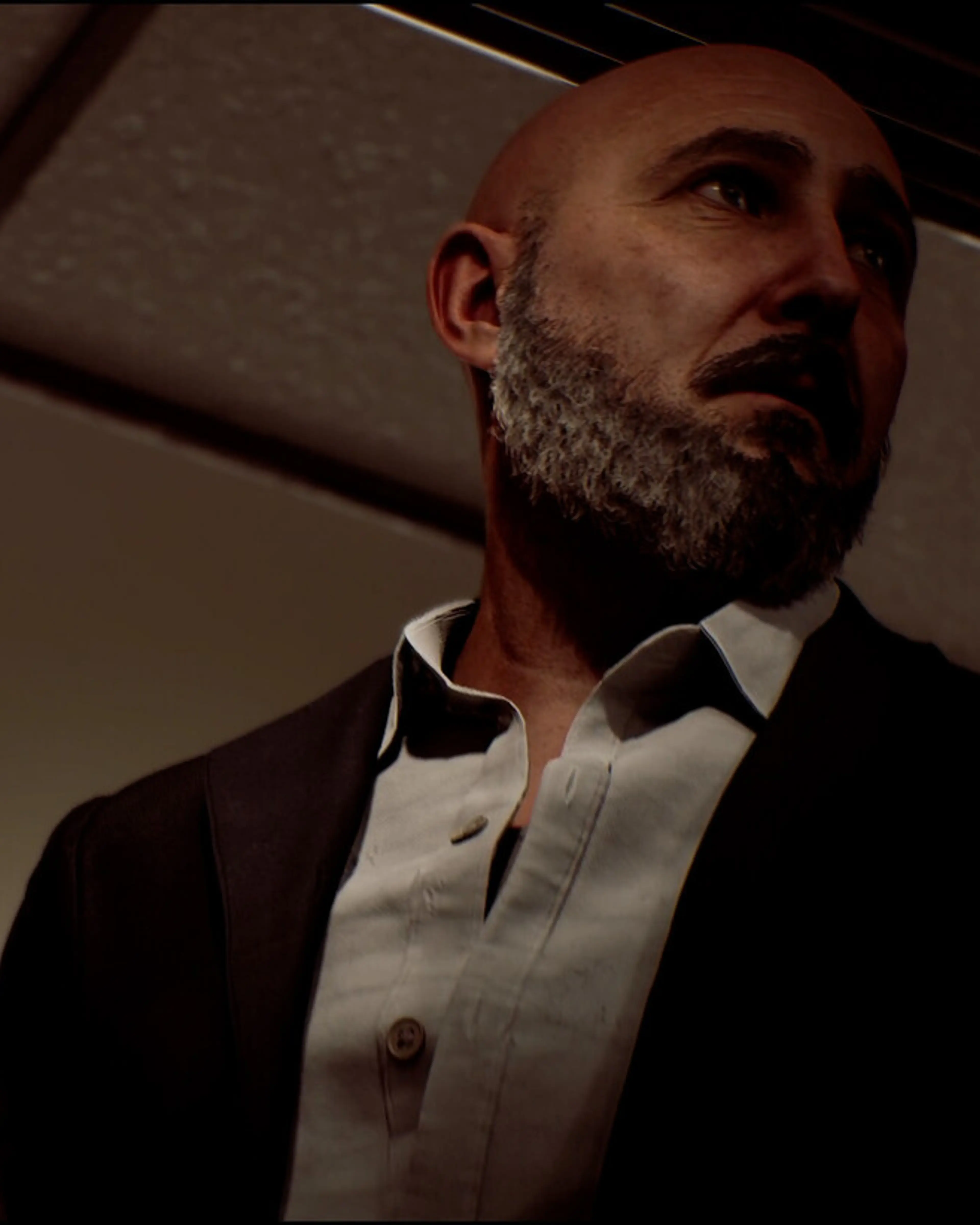 Richard has a grey beard and wears a waistcoat over a white shirt.