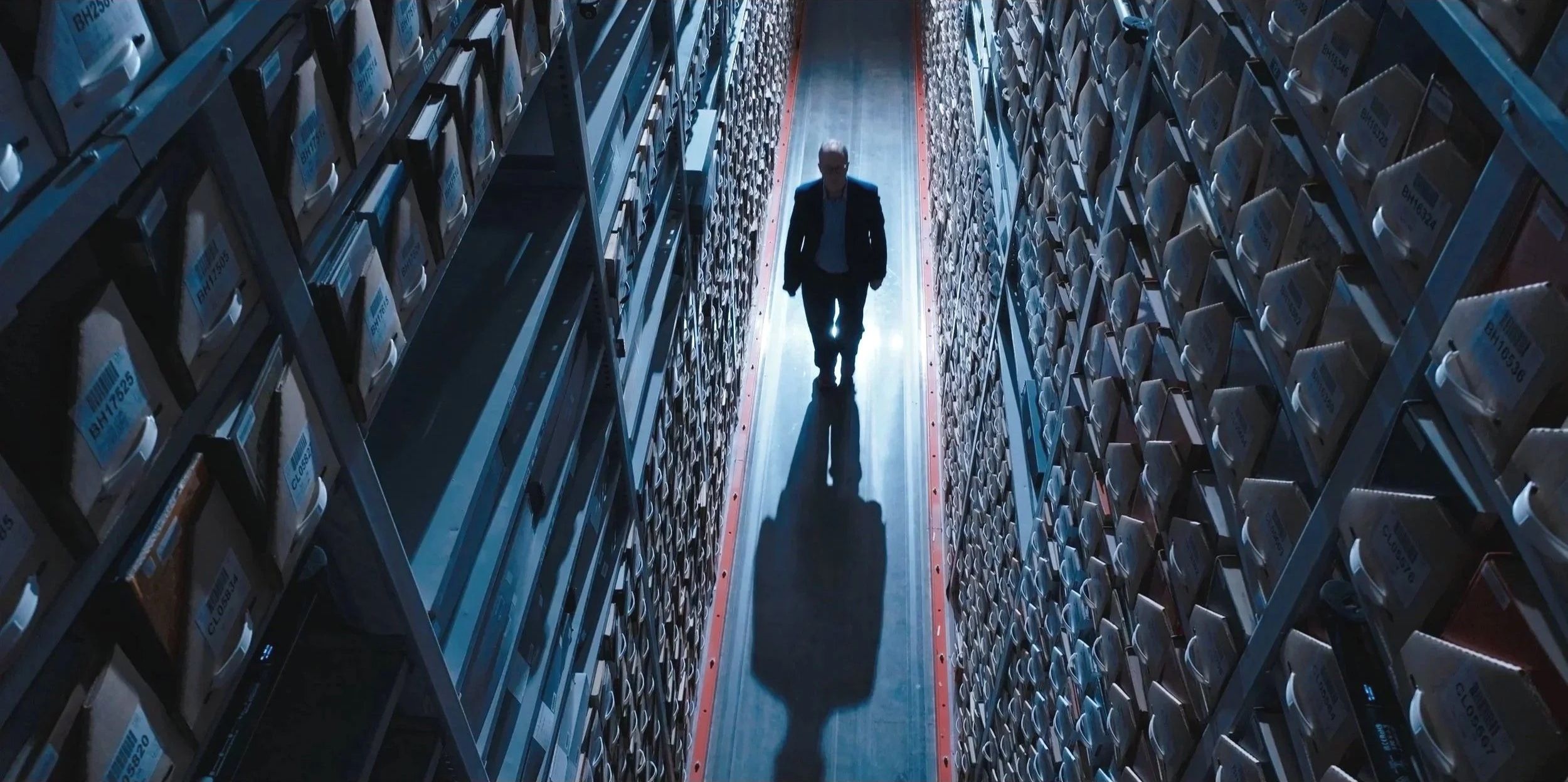 An unidentified person walks among archive files at the Center for the Impossible.