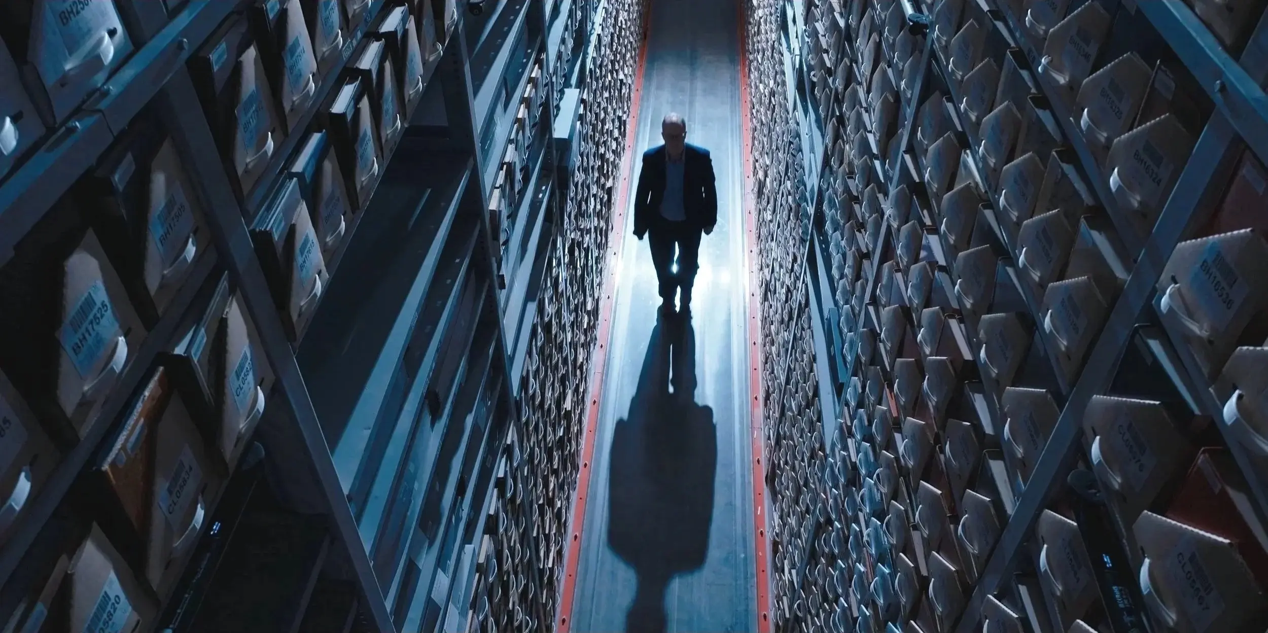 An unidentified person walks among archive files at the Center for the Impossible.