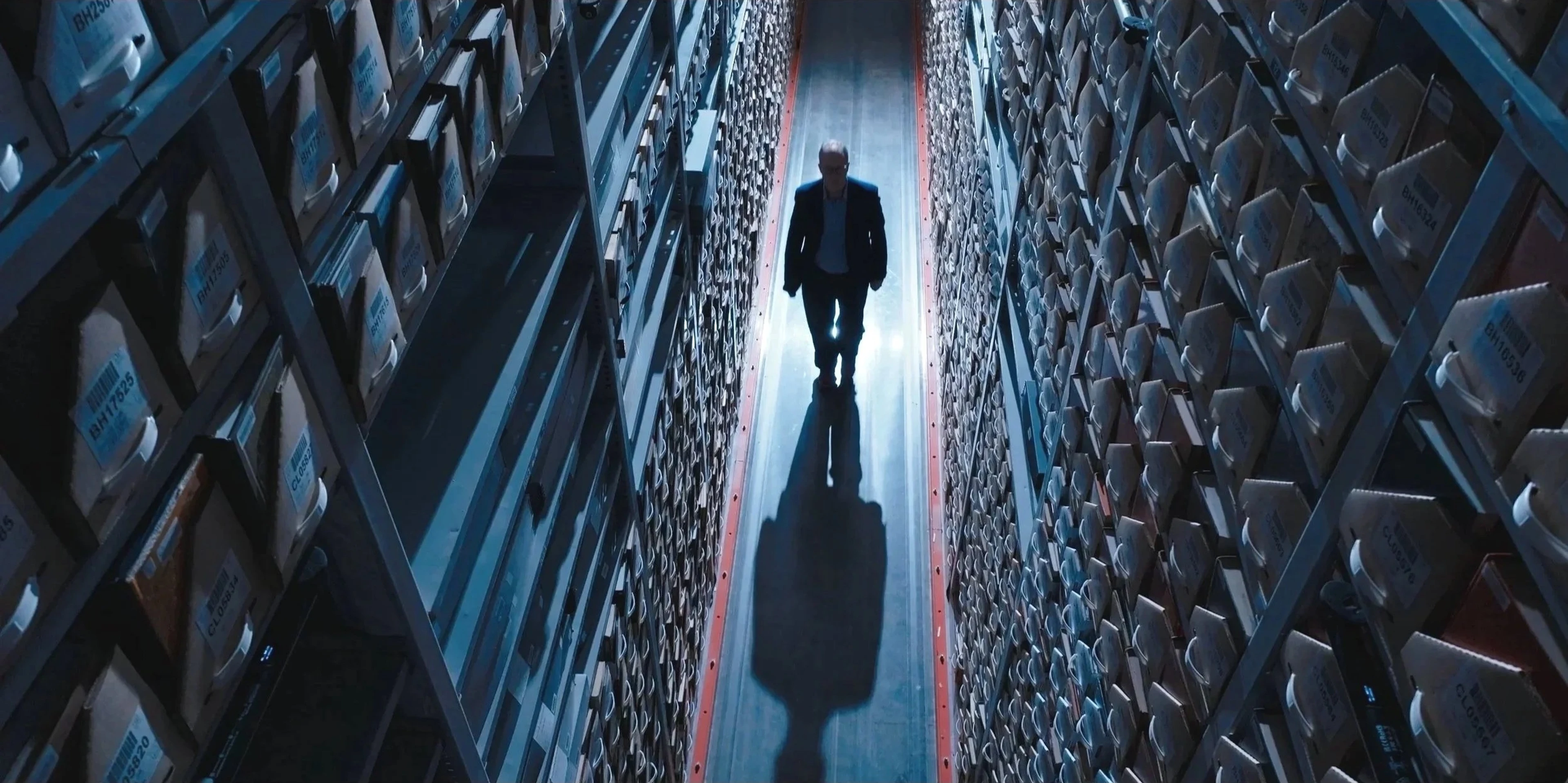 An unidentified person walks among archive files at the Center for the Impossible.