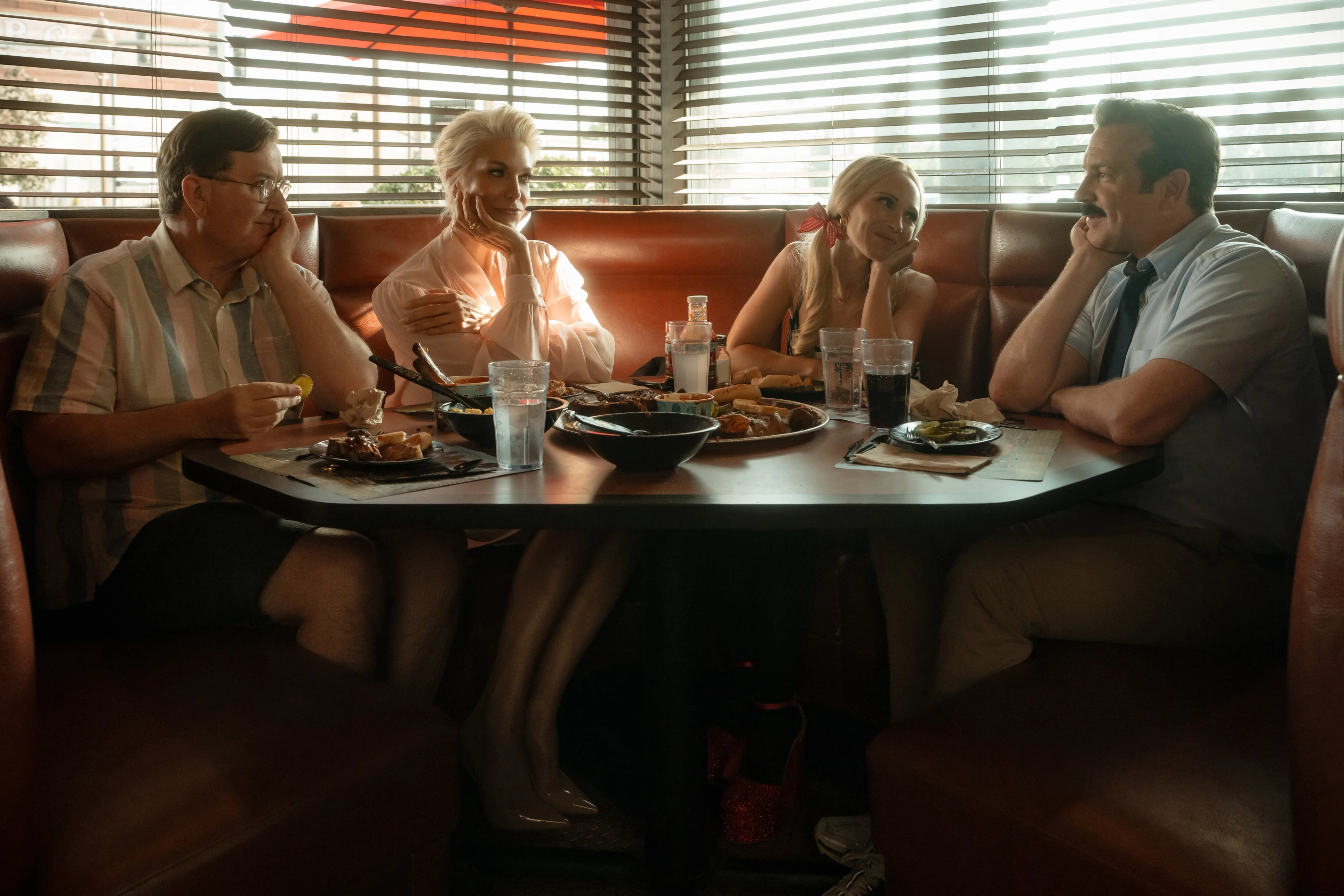 Jeremy Swift, Hannah Waddingham, Juno Temple, and Jason Sudeikis sit together in Ted Lasso Season 4.