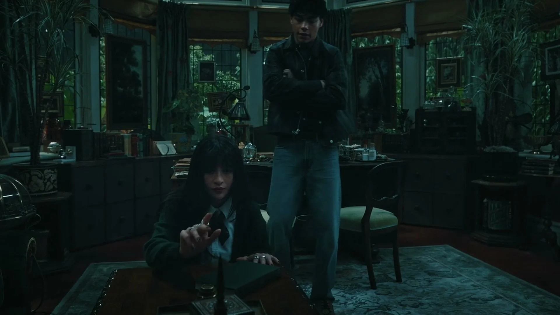 A student reaches toward a magical object while another watches in Coven Academy.