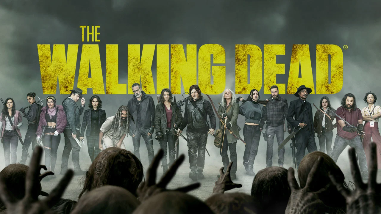 The main cast of The Walking Dead stands in front of the show title as walkers approach.