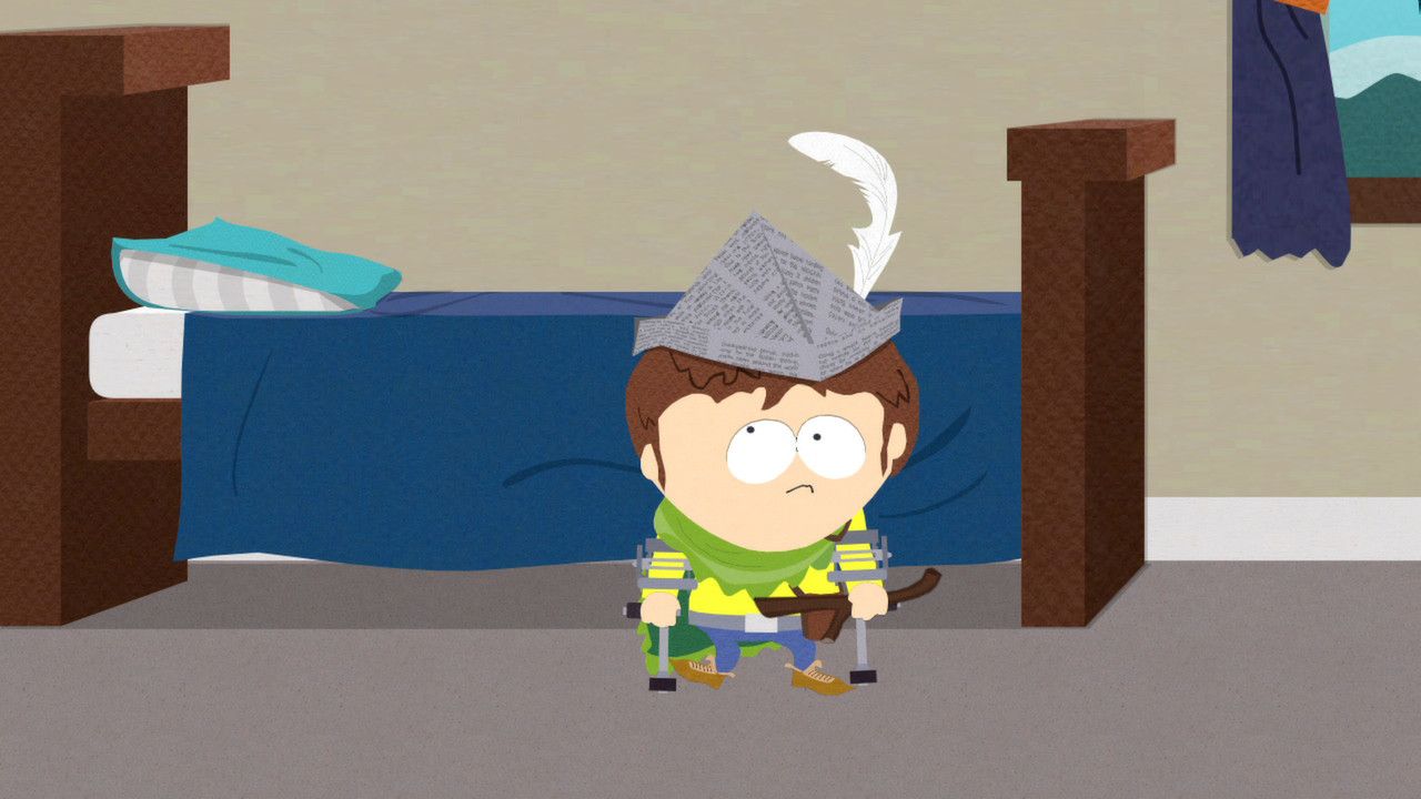 The New Kid in makeshift armor stands inside a bedroom beside a bed.