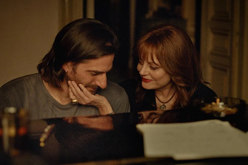 Susan Sarandon and Luca Marinelli sit together at a piano in The Echo Chamber.