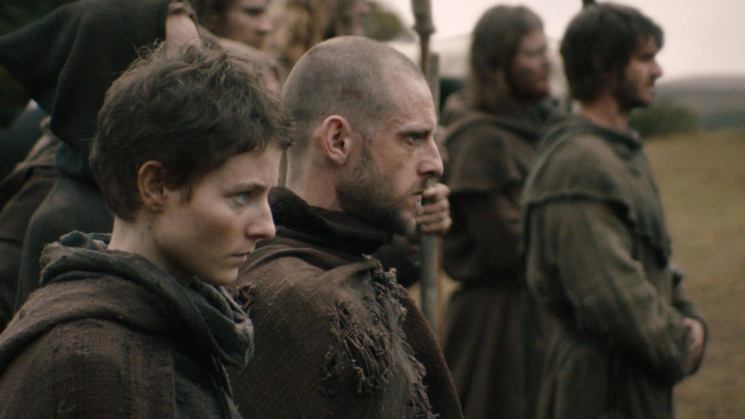 Thomasin McKenzie and Jamie Bell stand among the rebels, with Andrew Garfield behind them.