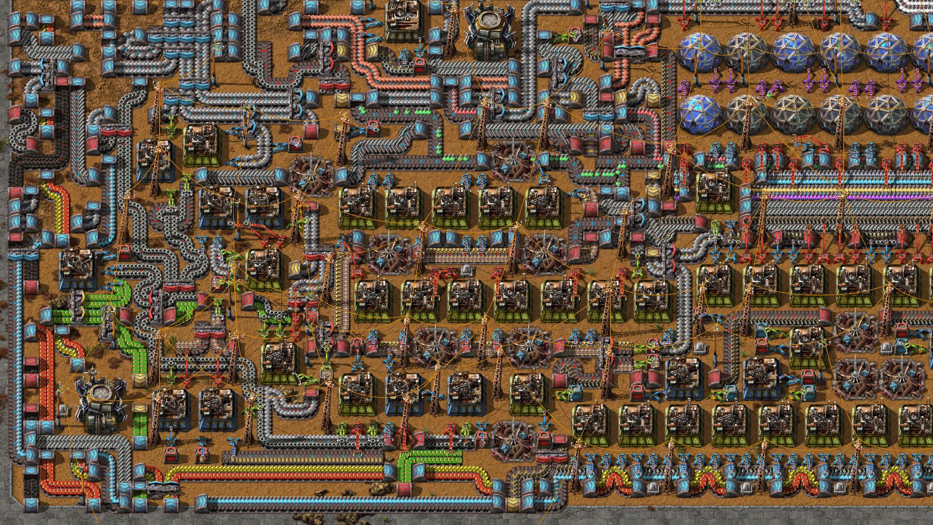 A dense Factorio factory contains belts, machines and lines of moving items.