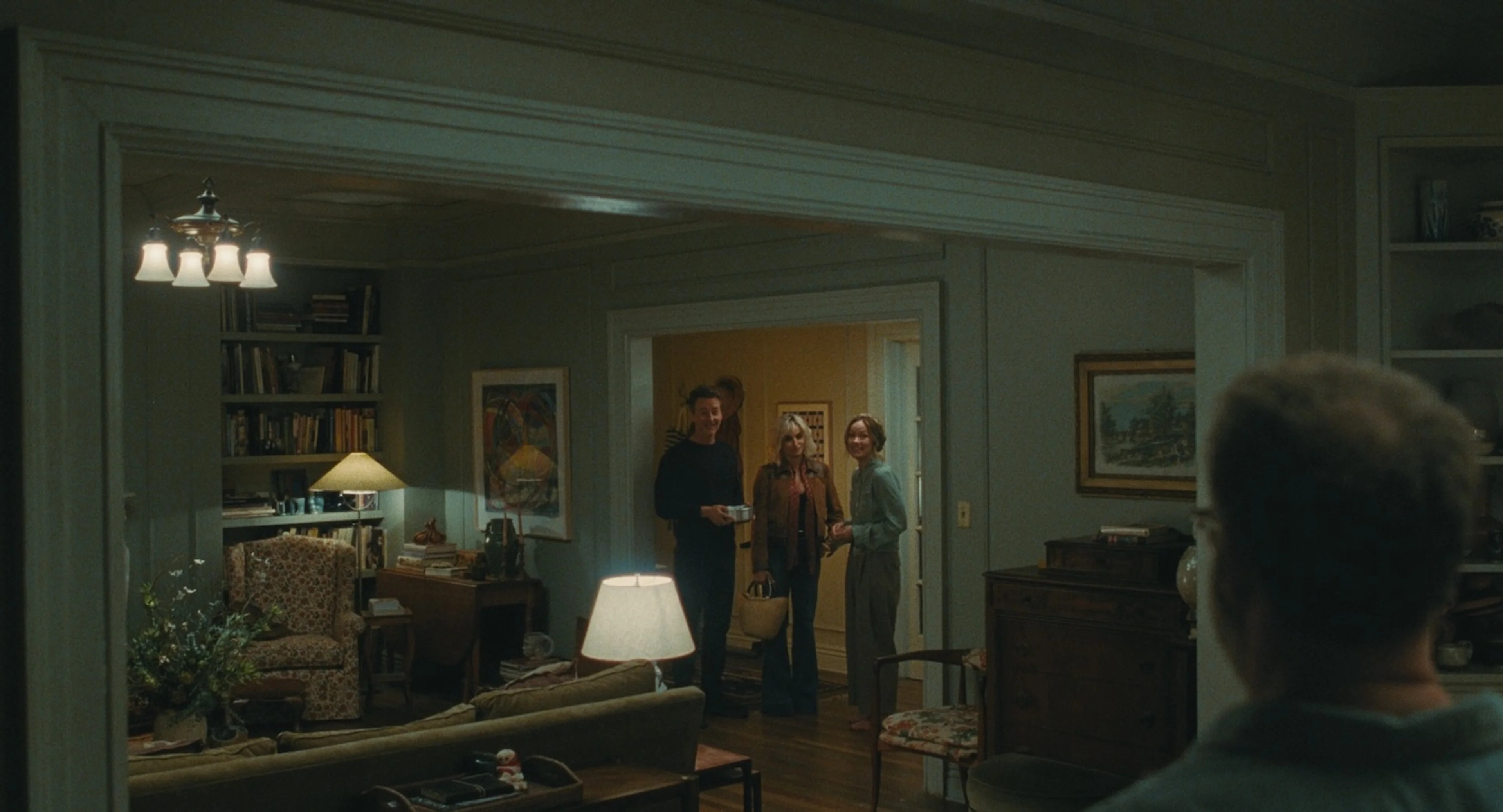 Hawk and Piña stand beside Angela in the doorway, with Joe in the foreground.