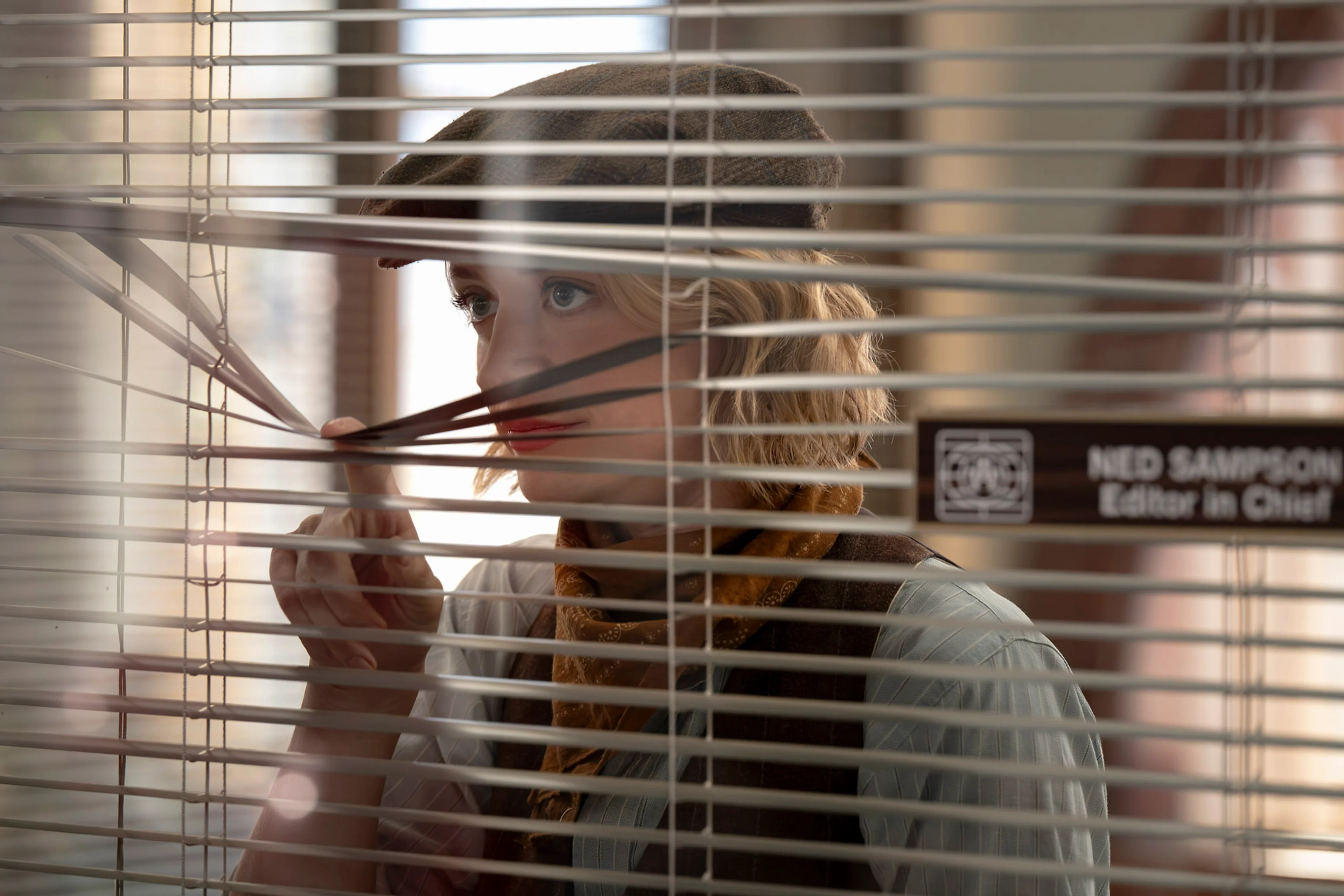 Mare lifts a window blind to look into Ned’s office.