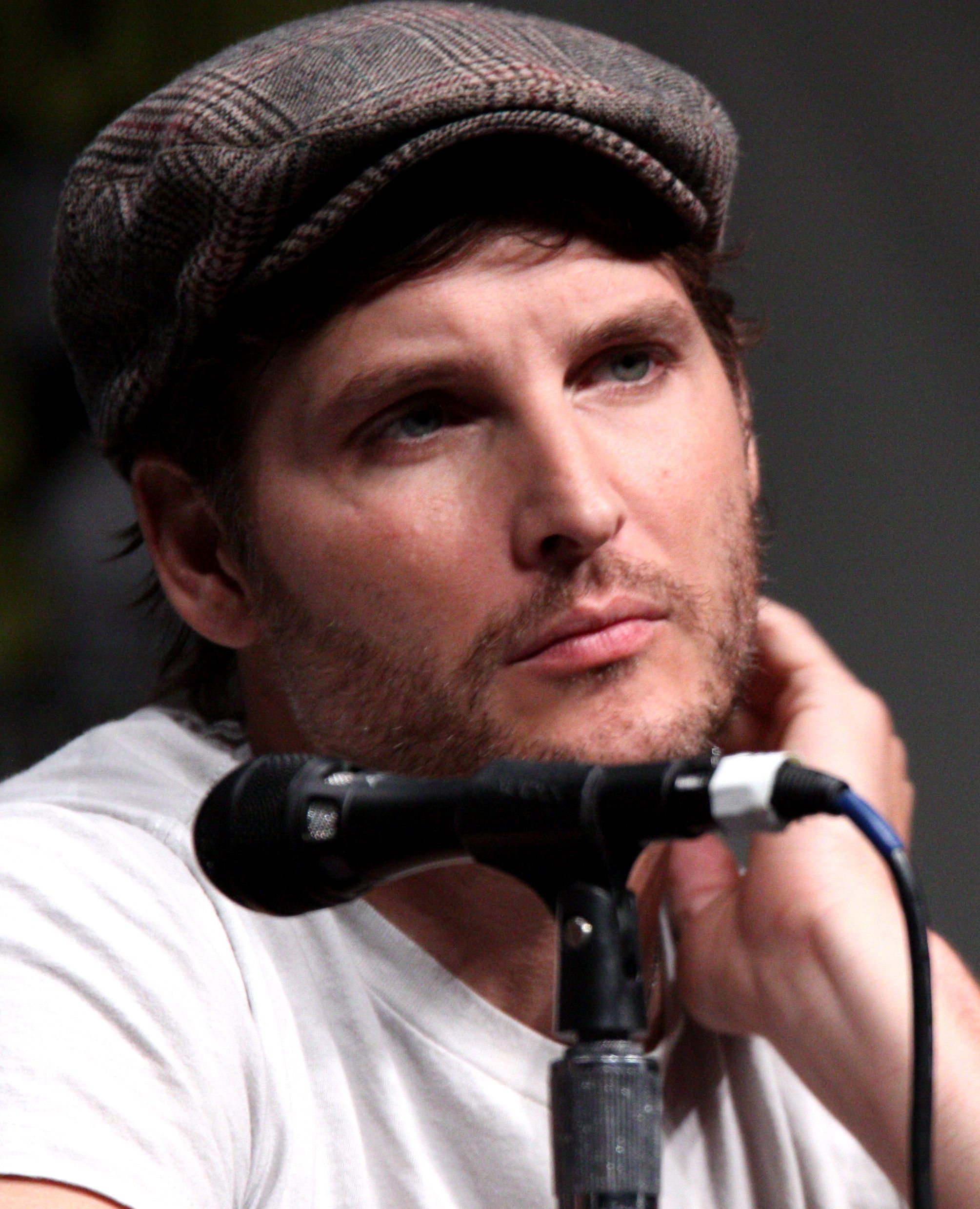Peter Facinelli speaking into a microphone at a 2012 Comic-Con panel.