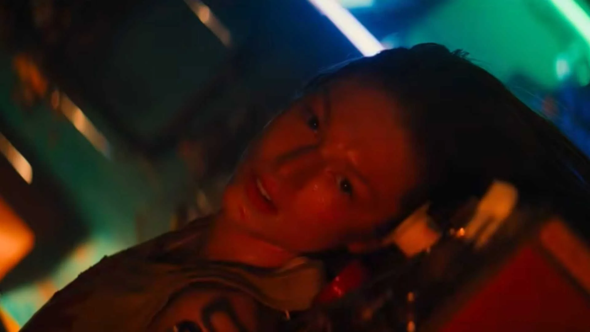 Hunter Schafer as Cora beneath colored lights in Blade Runner 2099.