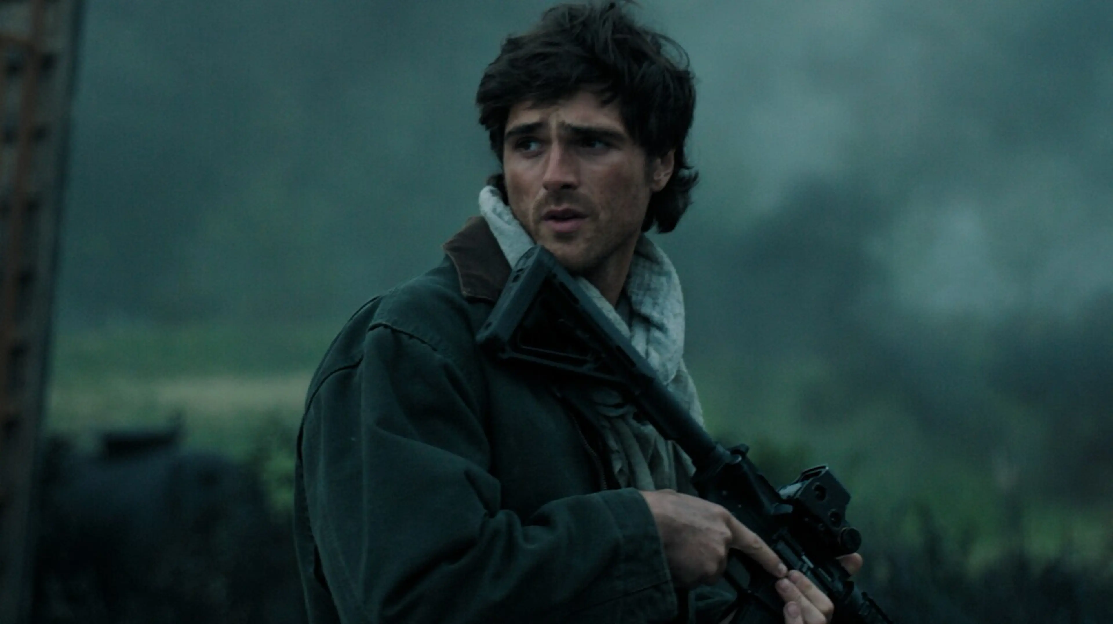 Jacob Elordi as Hig holds a rifle outdoors in The Dog Stars.