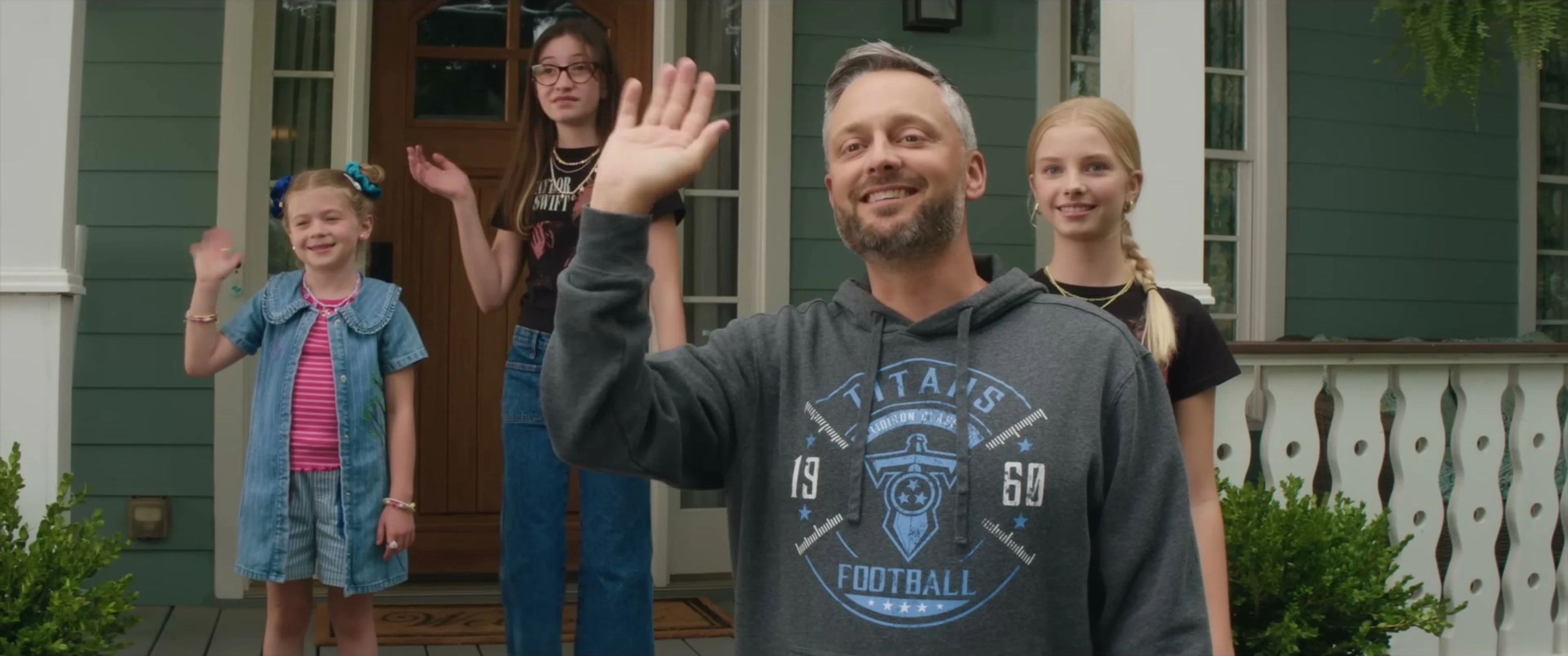 Nate stands on the front porch with his three daughters.