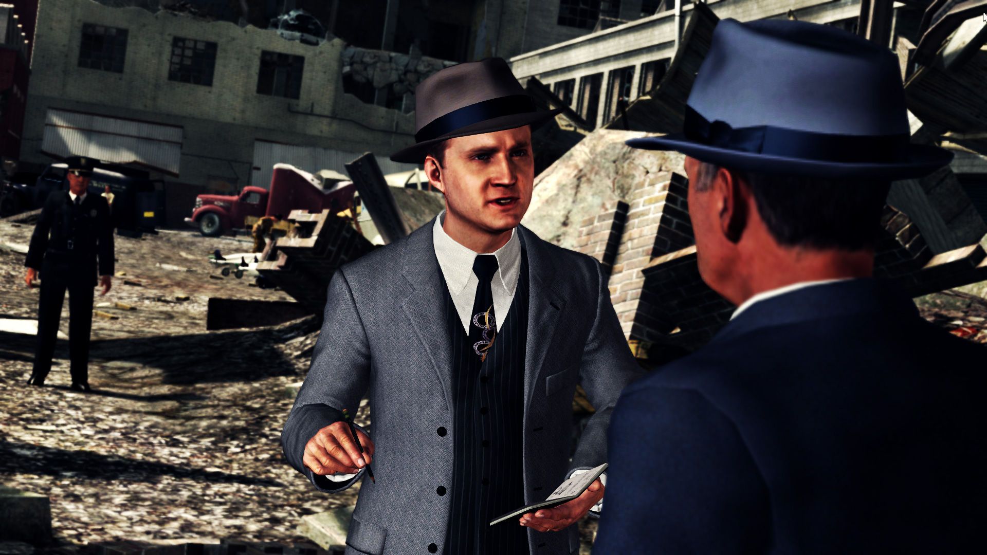 Cole Phelps holds an open notebook while another man speaks at a damaged outdoor site.