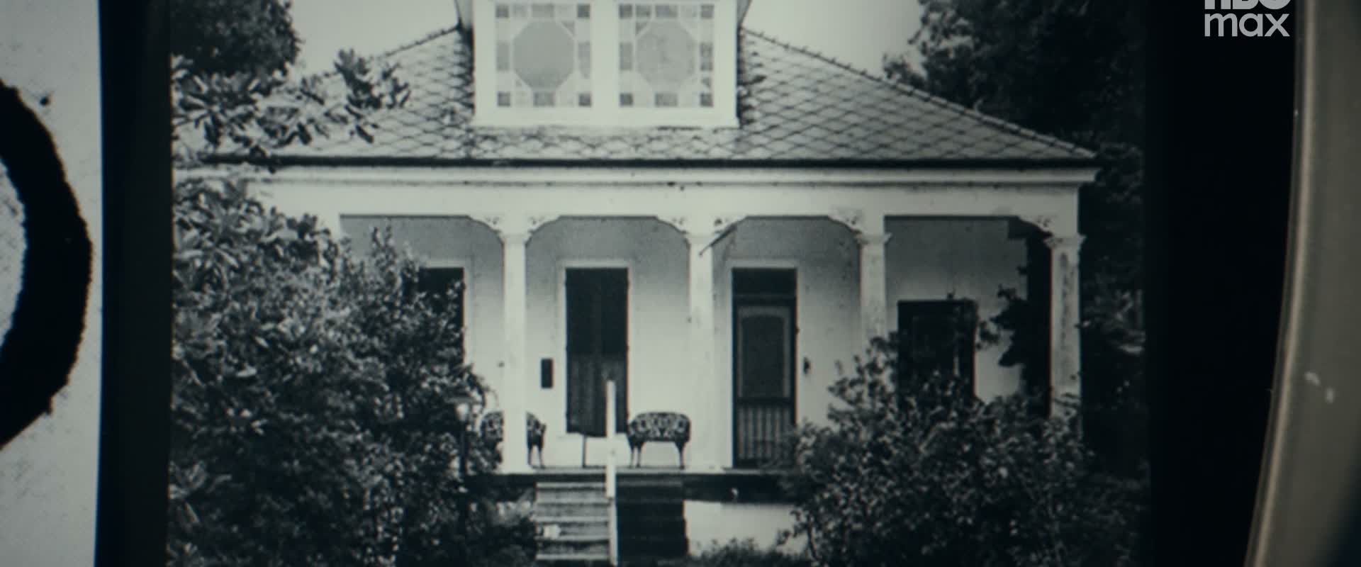 An archival photograph shows a house with a front porch.