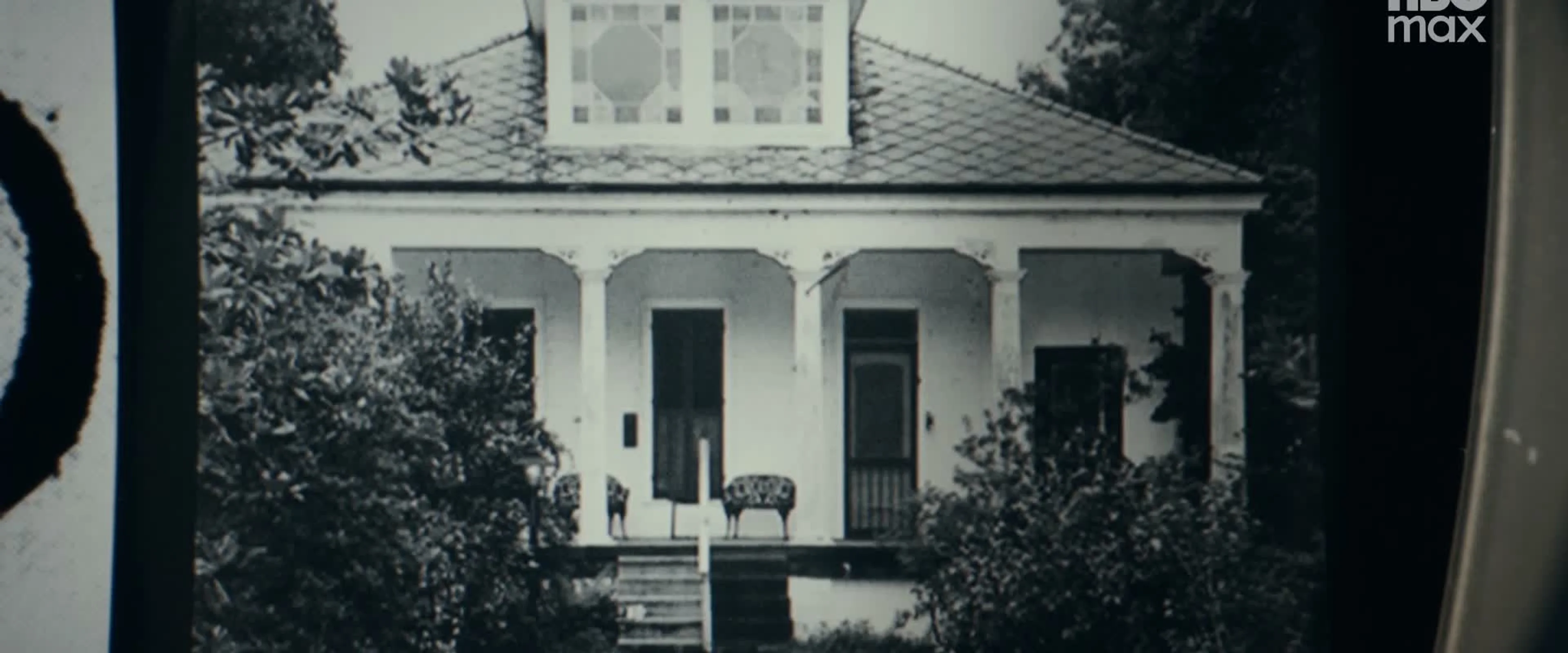 An archival photograph shows a house with a front porch.