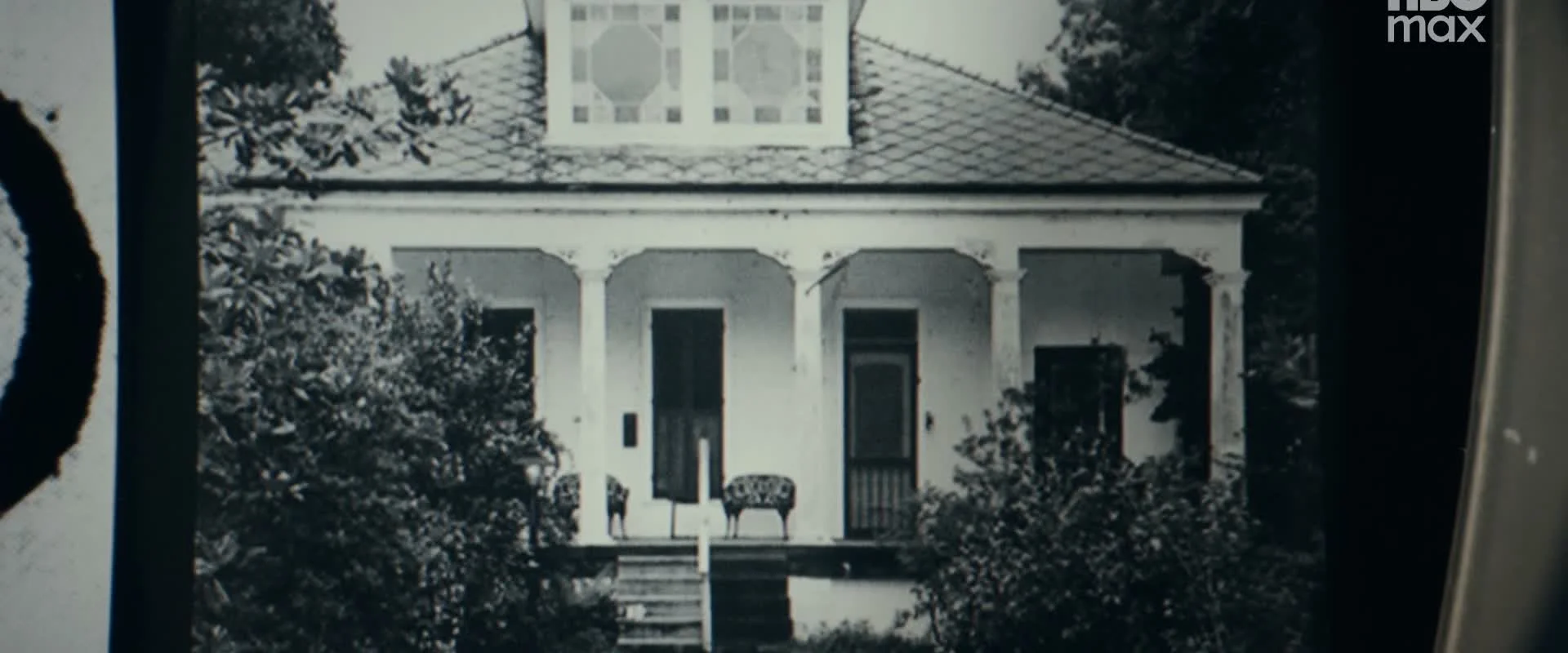 An archival photograph shows a house with a front porch.