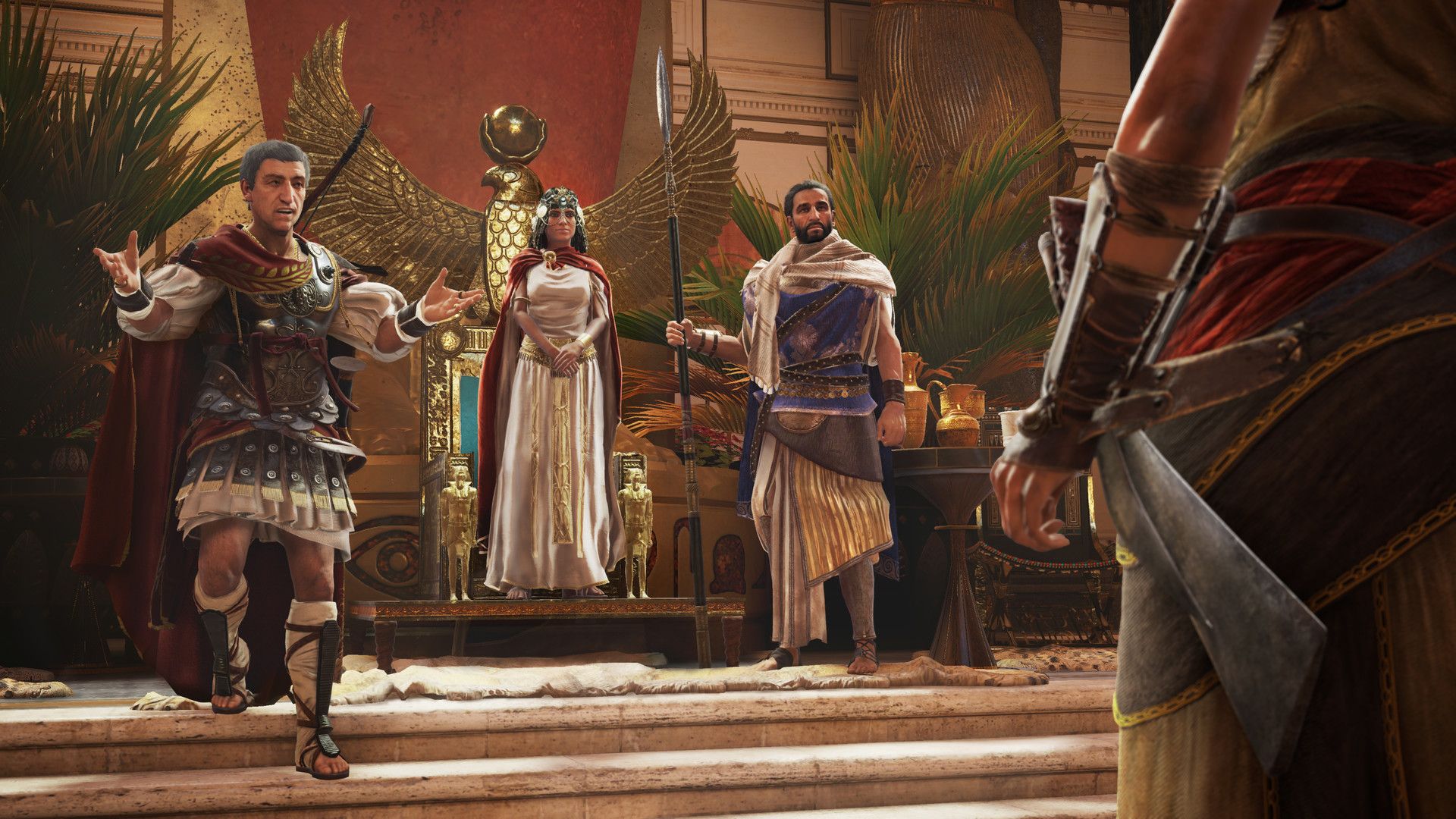 A group of people stands in an Egyptian hall during a story scene.