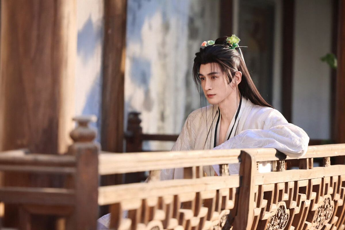 Zhang Yunlong as Xiao Yihan leans on a wooden bridge in a Fated Master and Disciple promotional photograph.