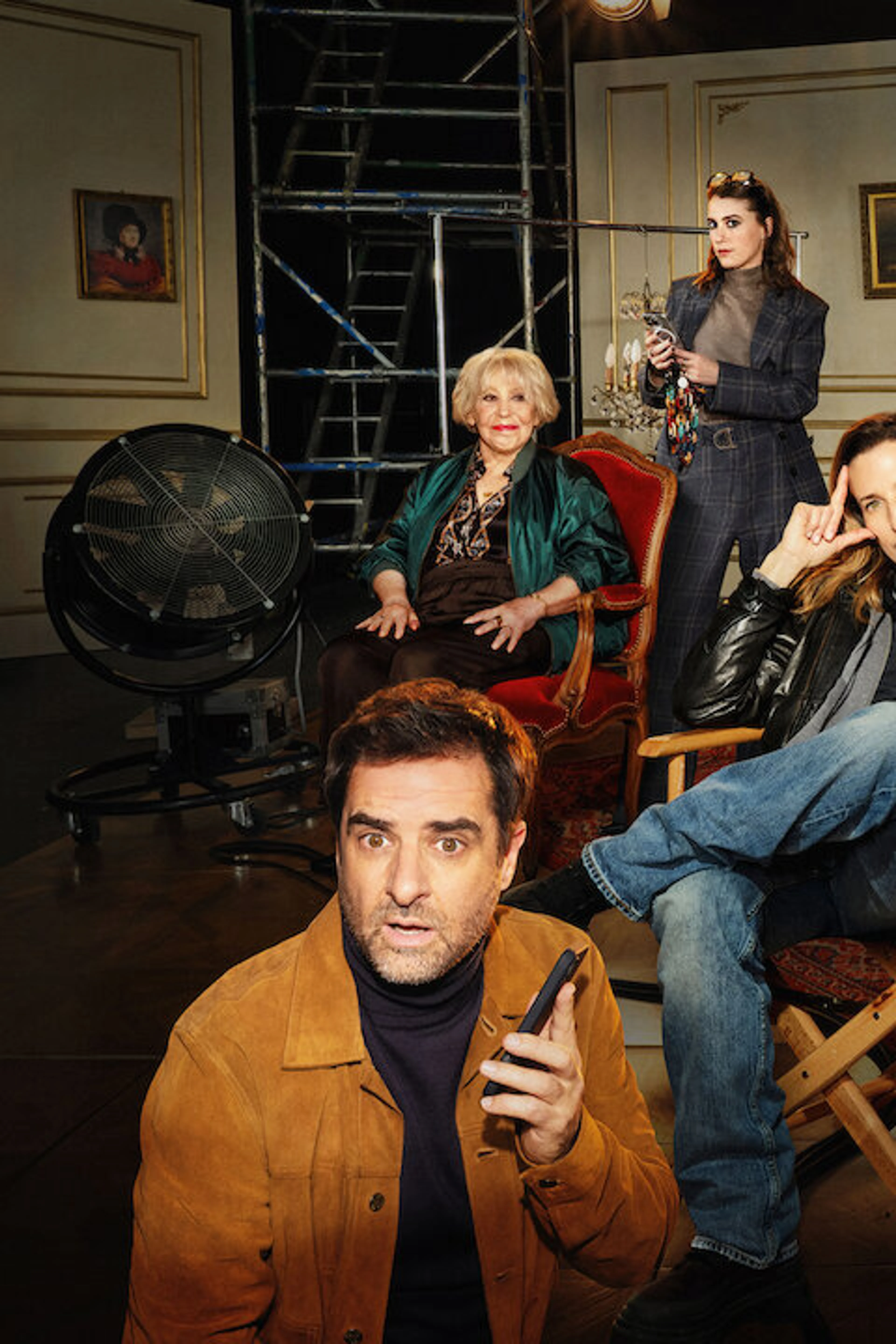 The Call My Agent! ensemble poses on a film set, with Camille Cottin seated at center.