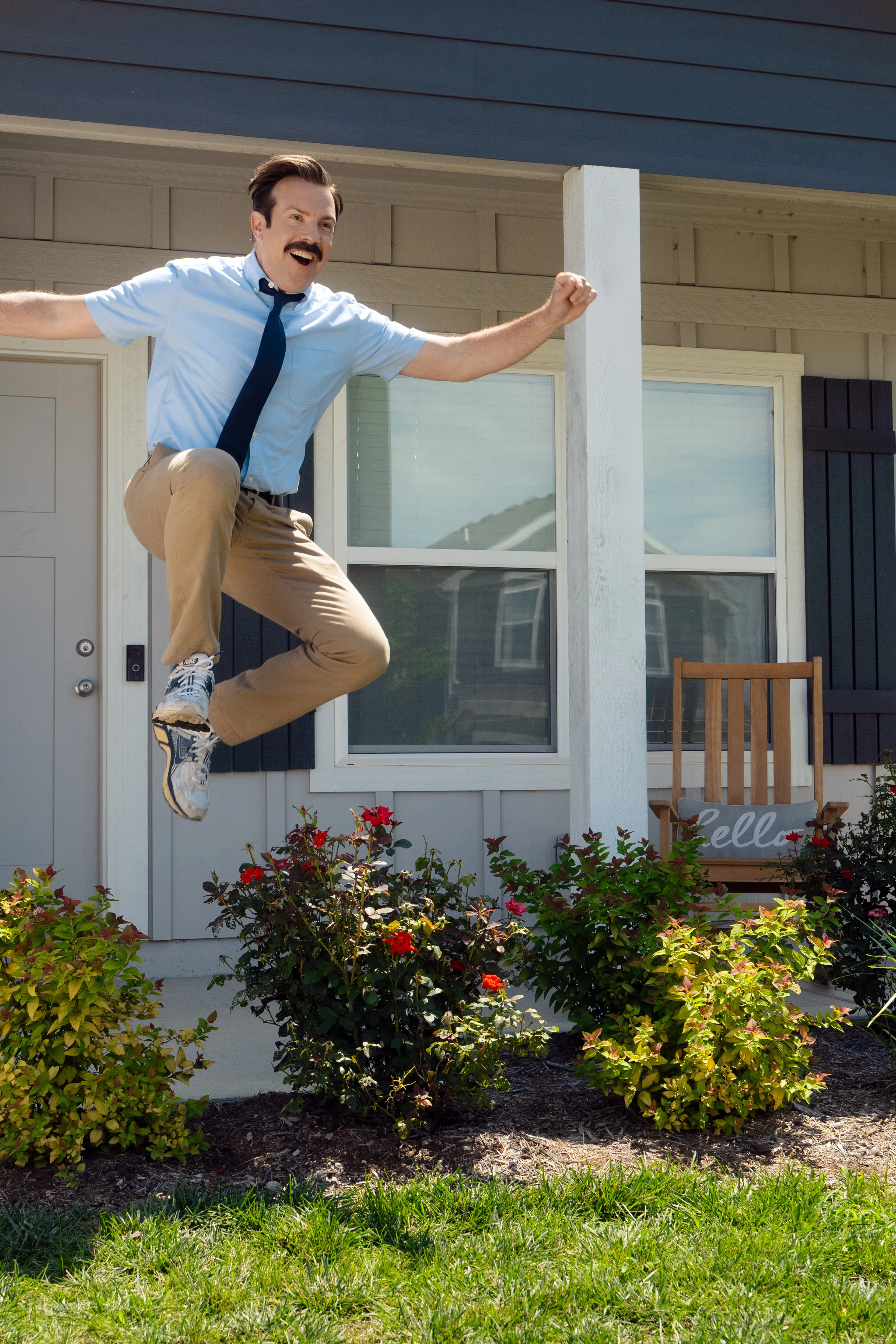Jason Sudeikis as Ted Lasso outside a house in Ted Lasso Season 4.