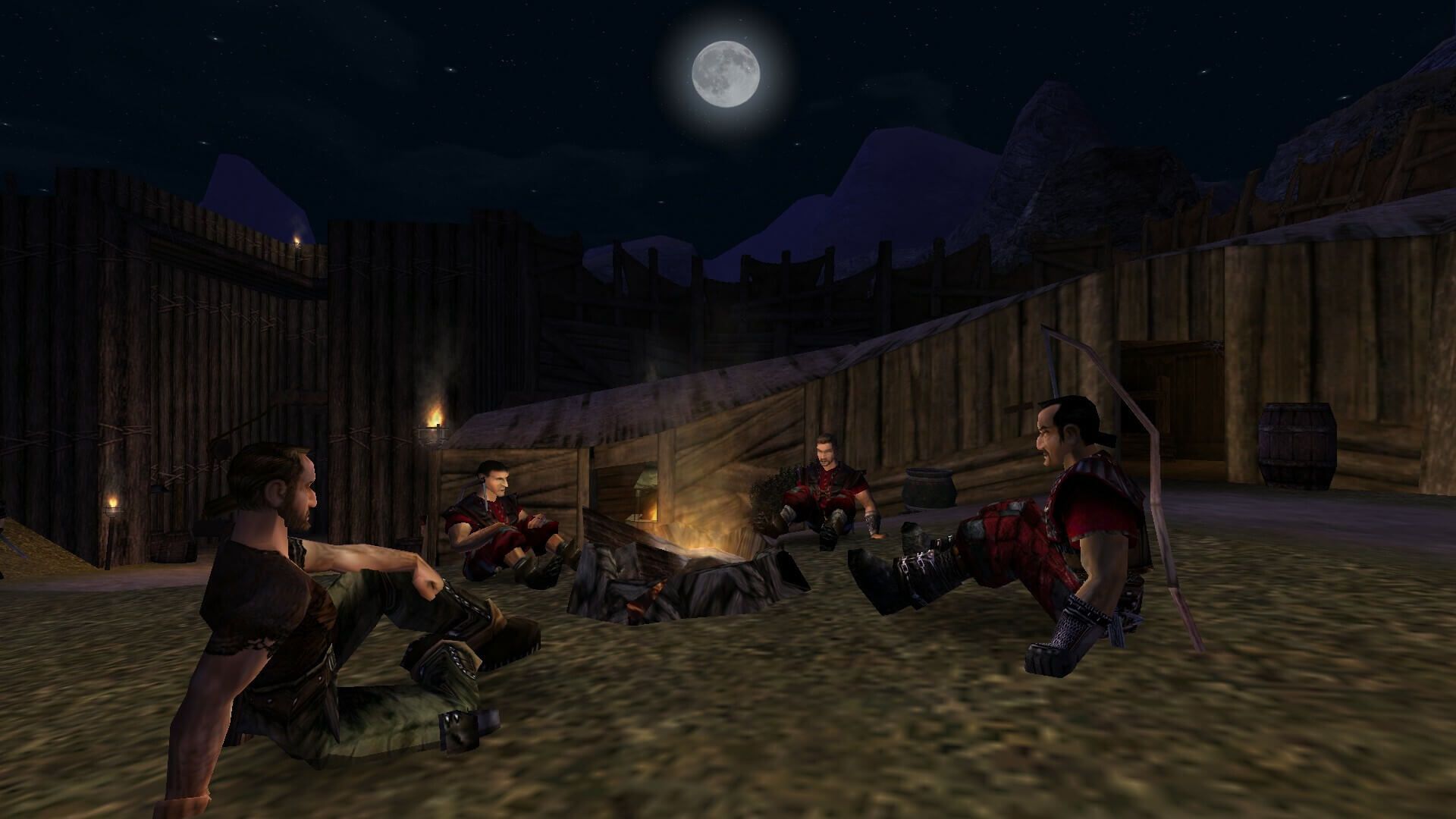 Gameplay screenshot: adventurers gather around a campfire inside a wooden fort under the moon in Gothic Classic.