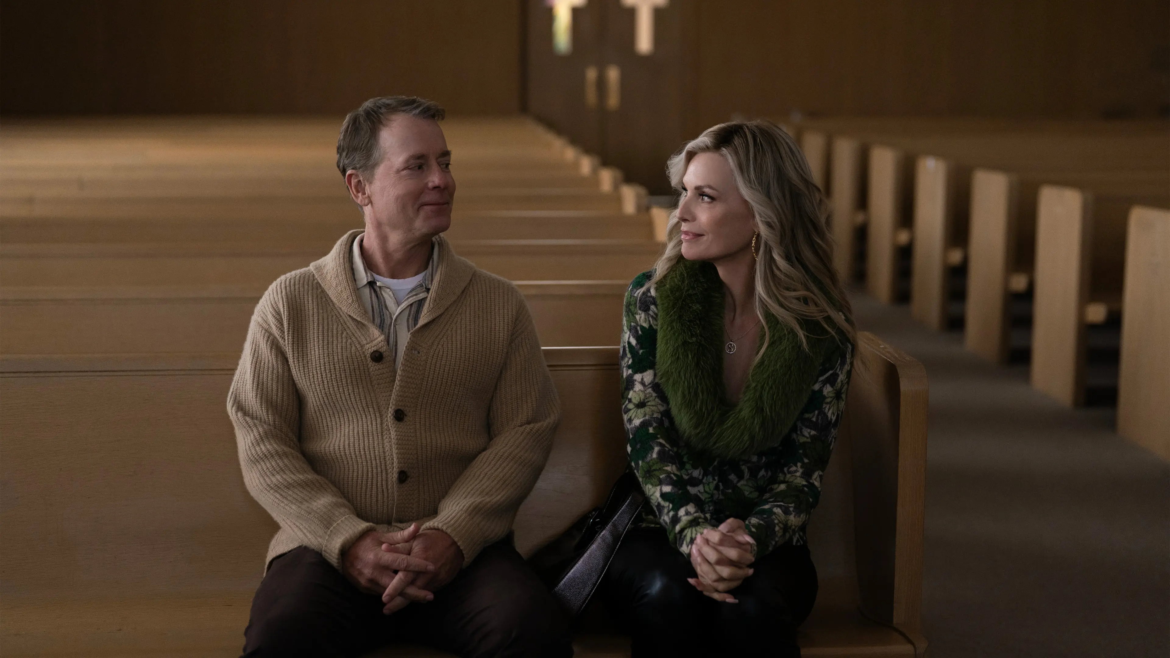 Greg Kinnear as Kenny and Michelle Pfeiffer as Shyanne sit together in a church pew.