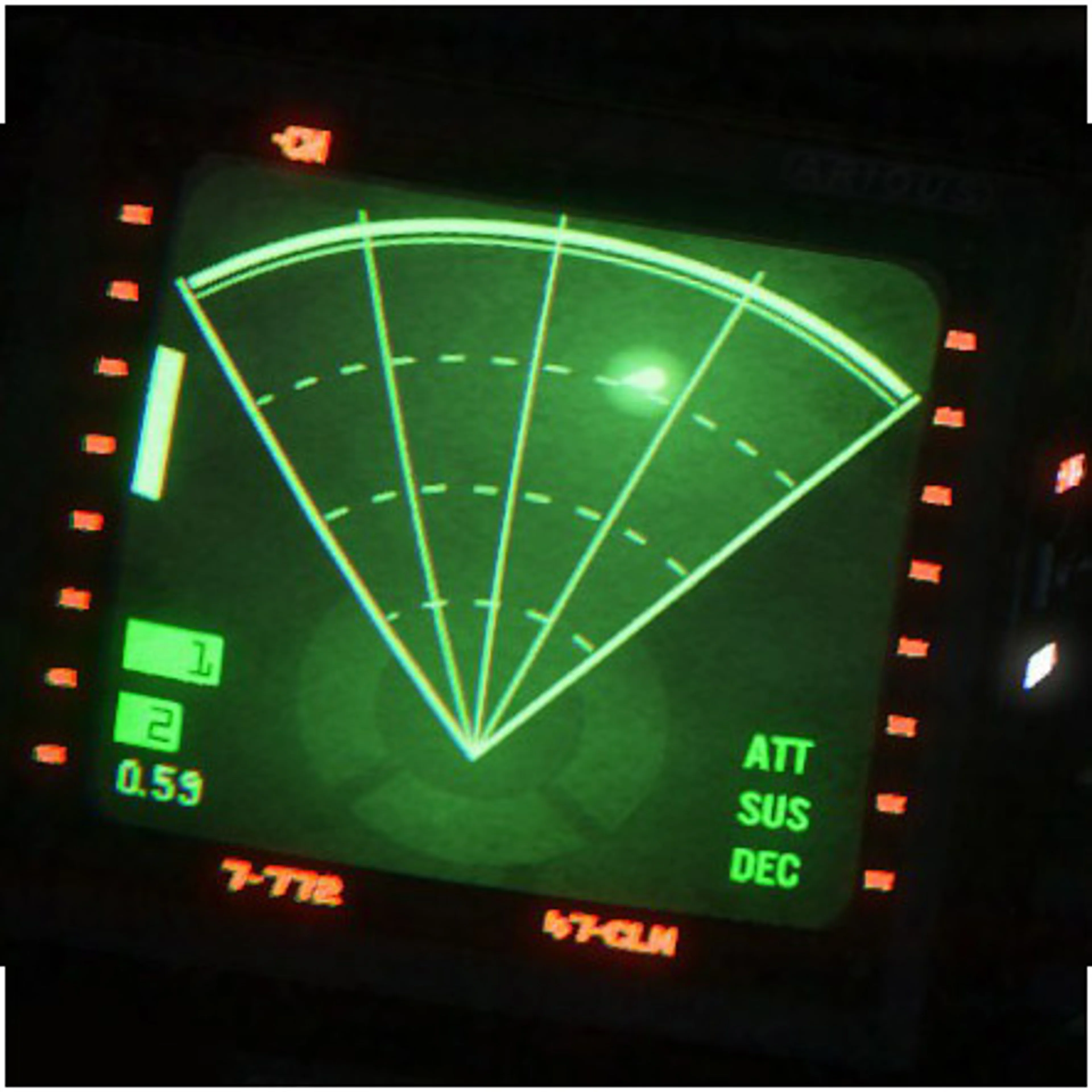 Official close-up of the Alien: Isolation green motion tracker, showing the forward cone, side and rear quarter-rings, a bright movement dot, a distance number at lower left and a rectangular objective marker at the edge.
