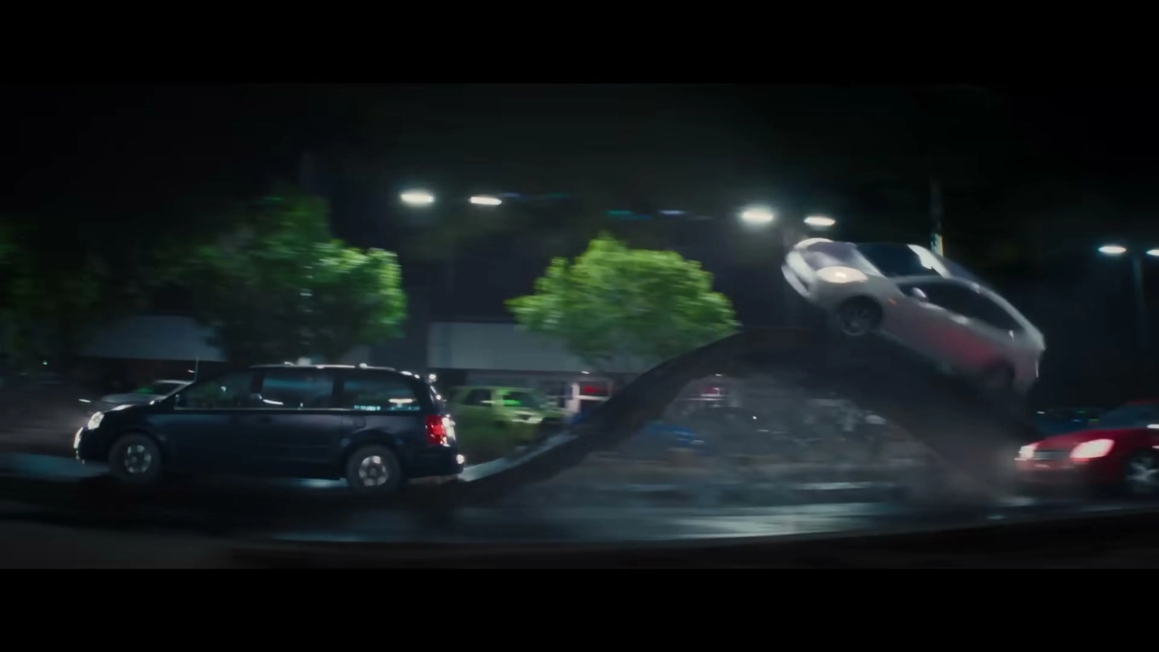 A car flies above traffic during a nighttime chase in Coyote vs. Acme.