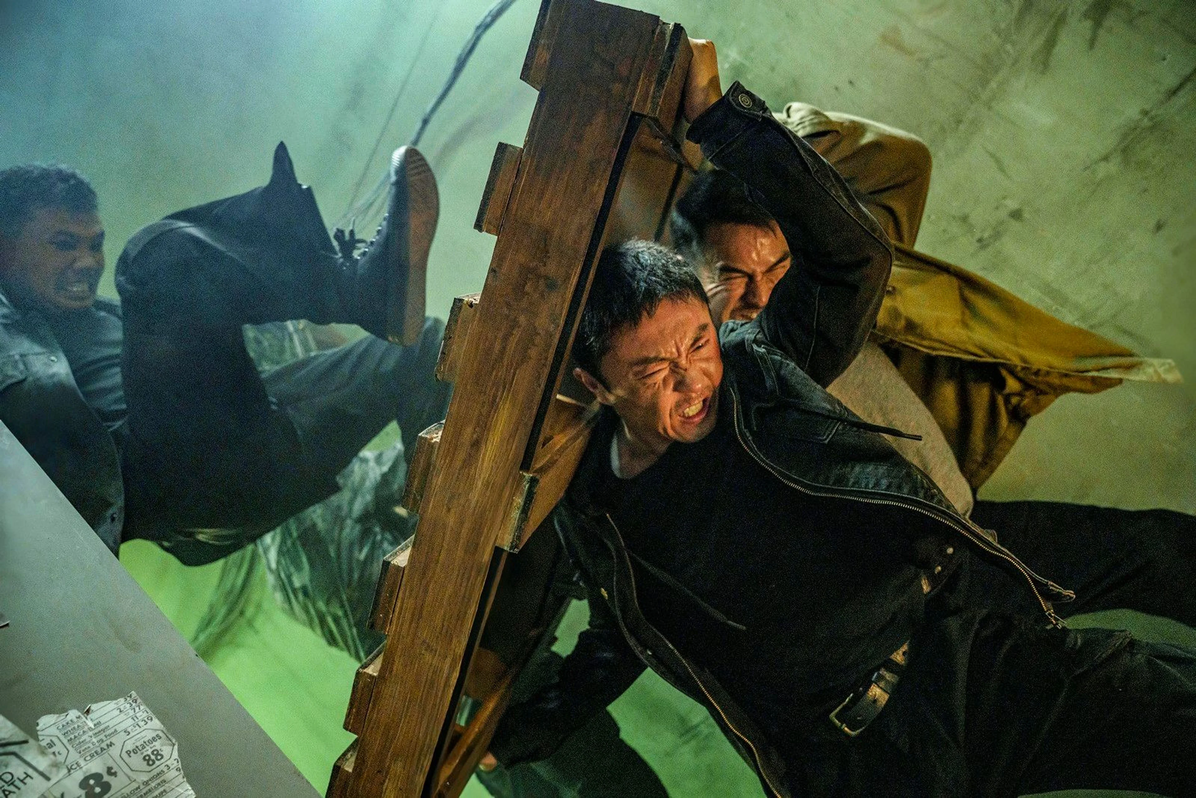 Wang Wei holds a wooden barrier during a fight.