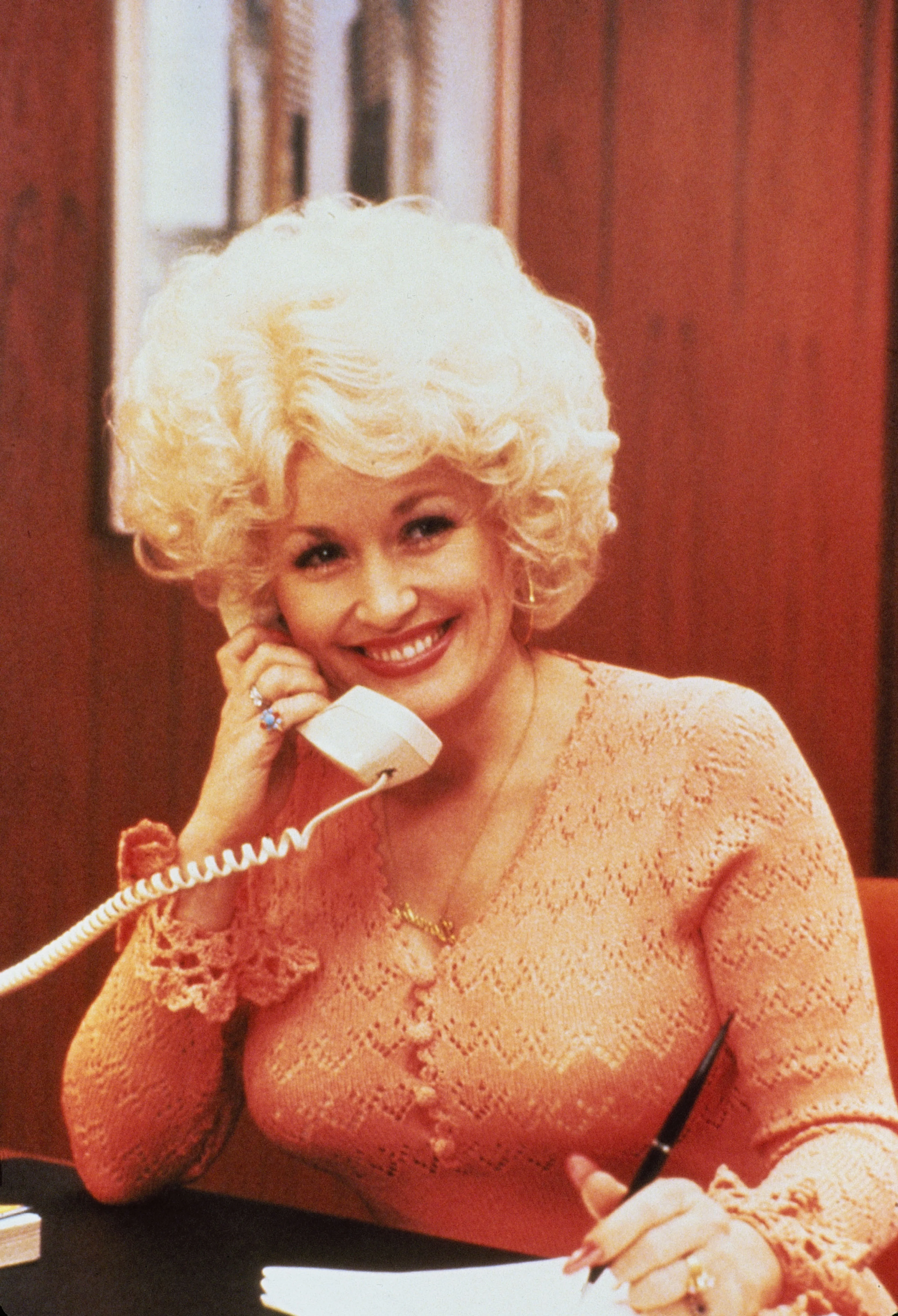 Dolly Parton talks on a desk phone in 9 to 5.