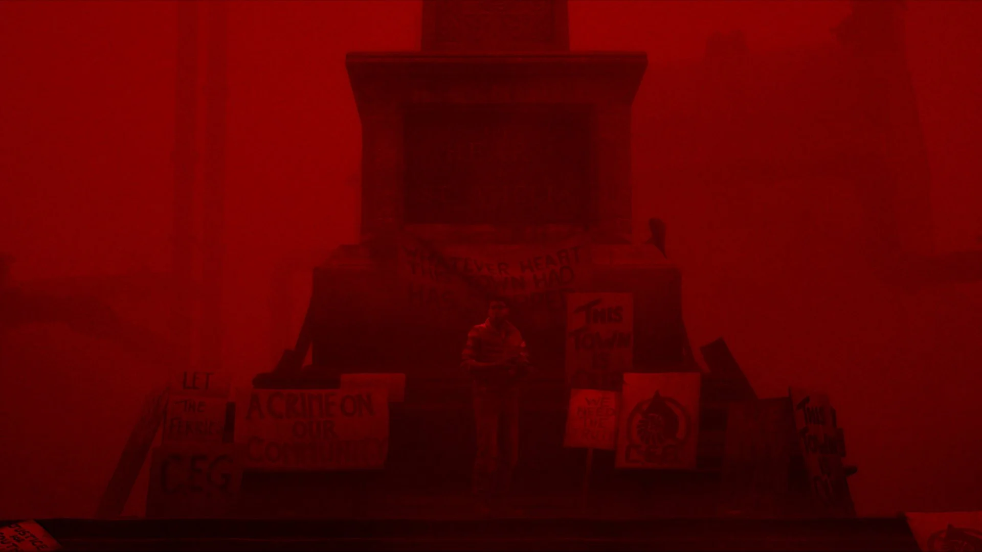 A dark building looms through a red haze in Silent Hill: Townfall.