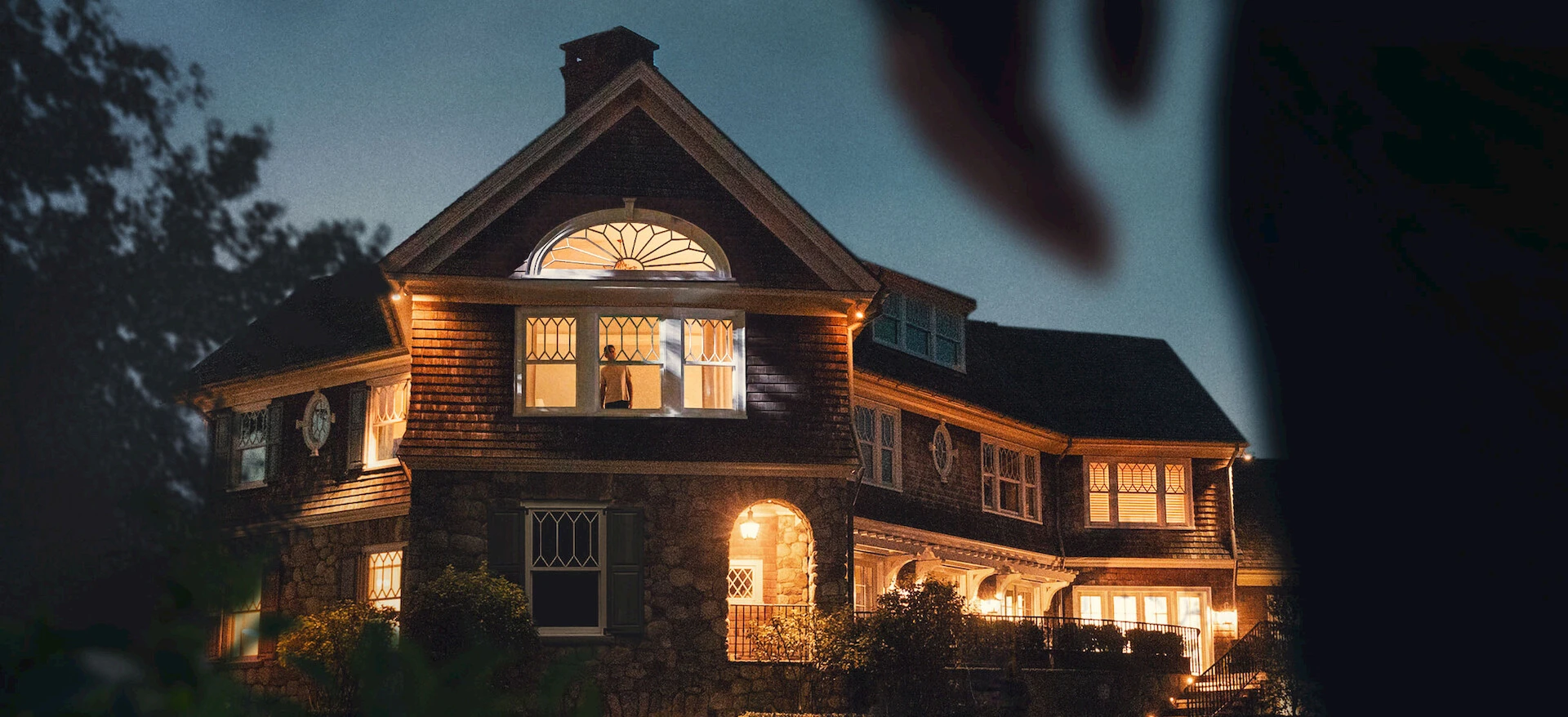 Official The Watcher house artwork shows a lit home at night.