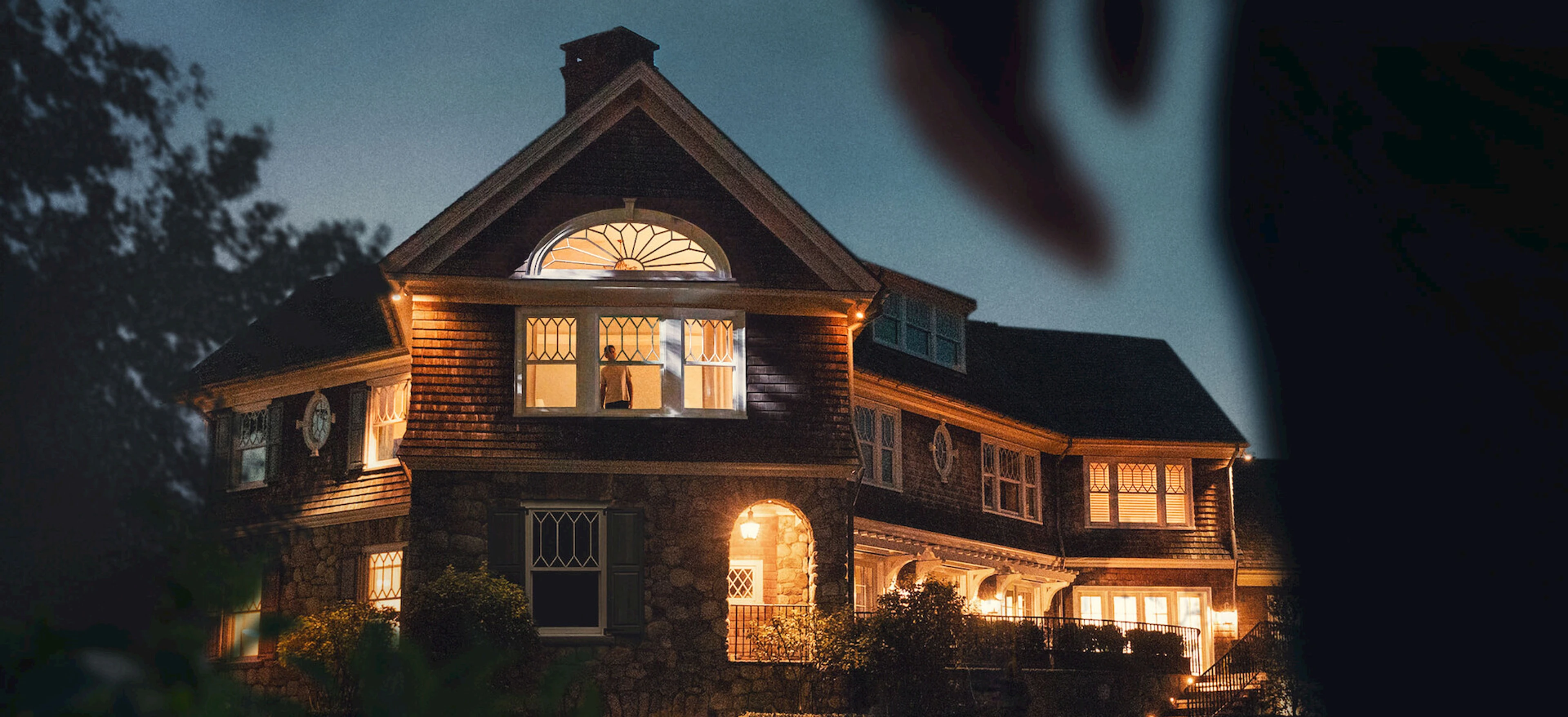 Official The Watcher house artwork shows a lit home at night.