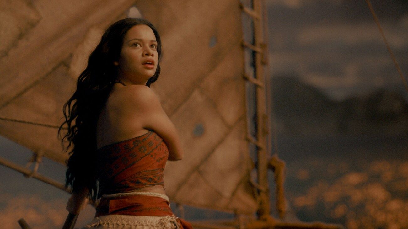 Moana looks back while standing on a boat.