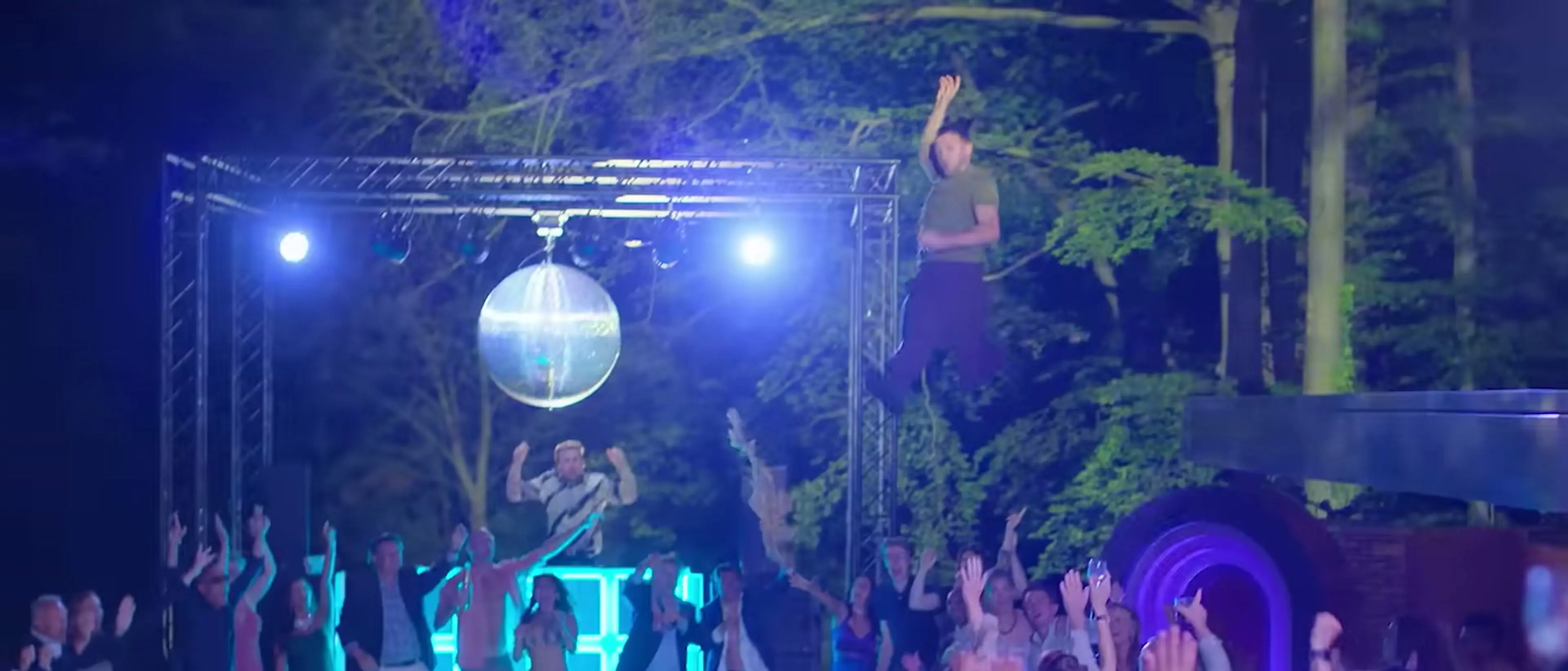 Members of the dinner club gather under bright lights at an outdoor celebration in The Perfect Lie.