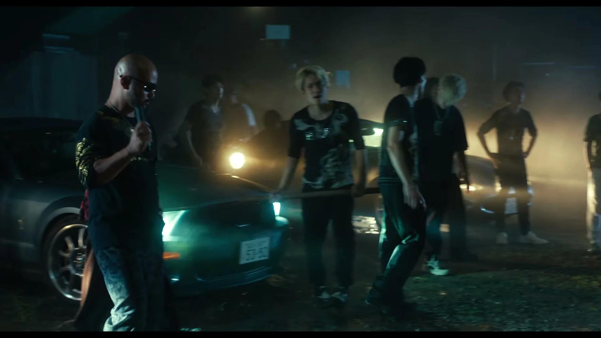 A group of men stands beside cars at night in the new Sins of Kujo movie teaser.
