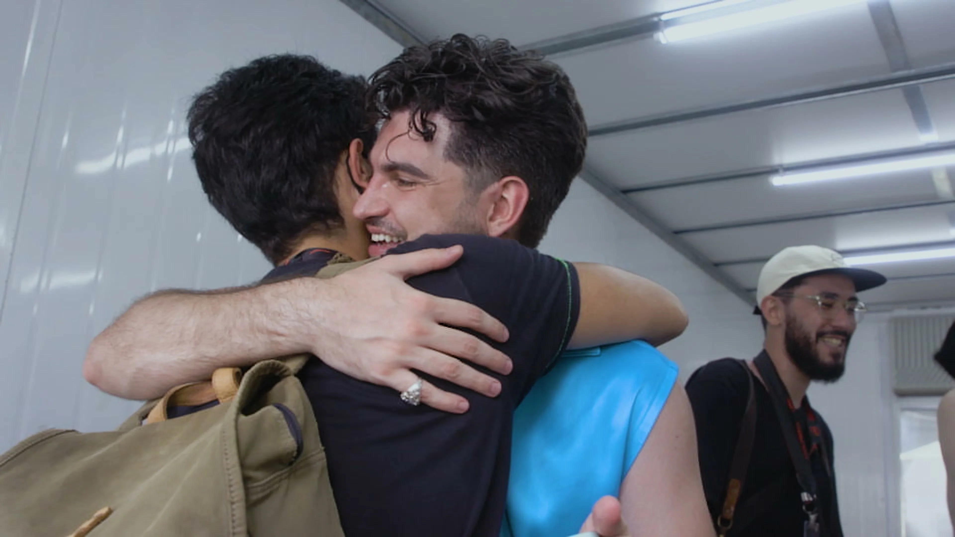 Jão embraces someone in an intimate moment from the teaser.