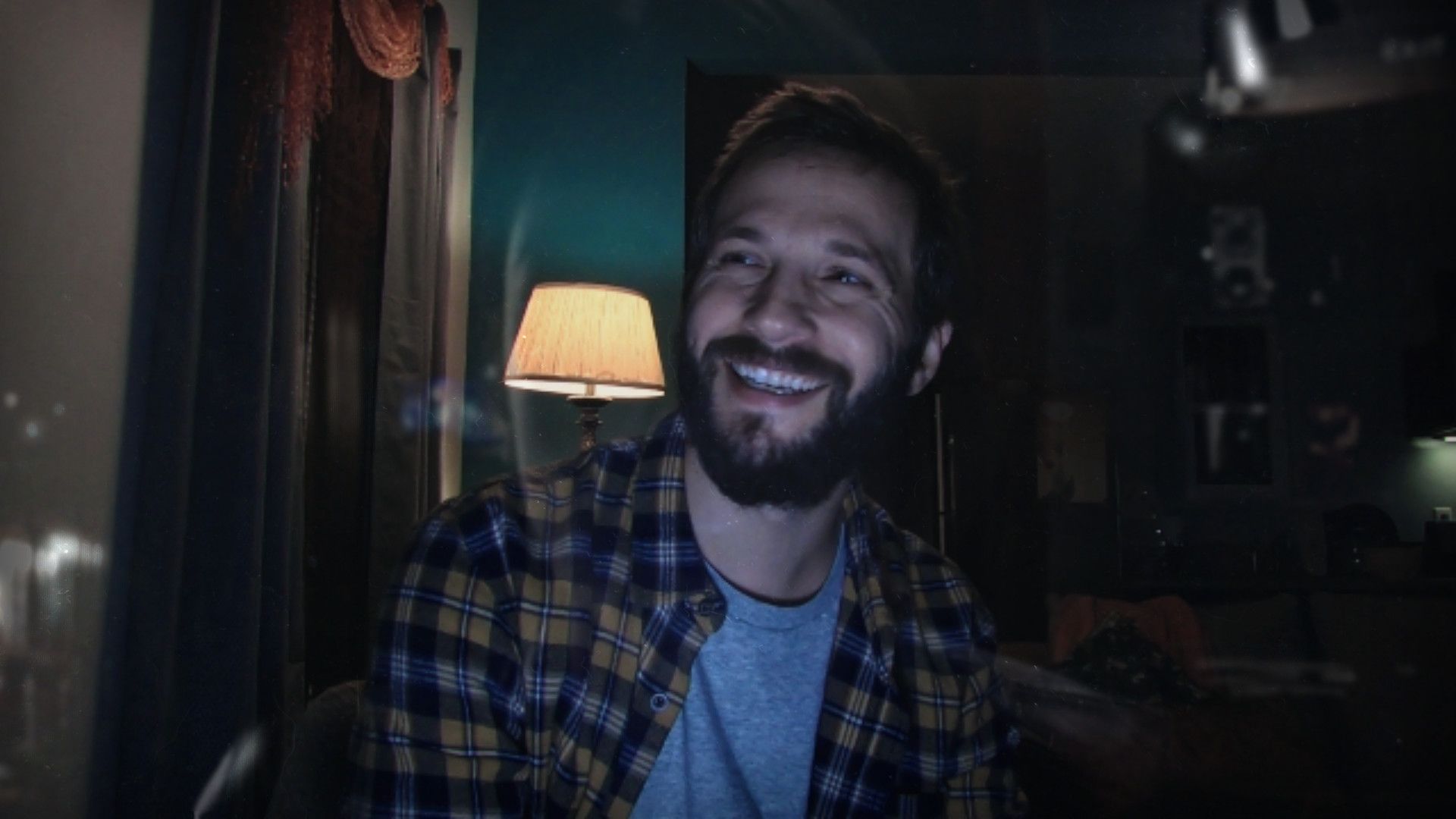 A man appears in a dimly lit room beside a lamp, showing another private video recording in the database.